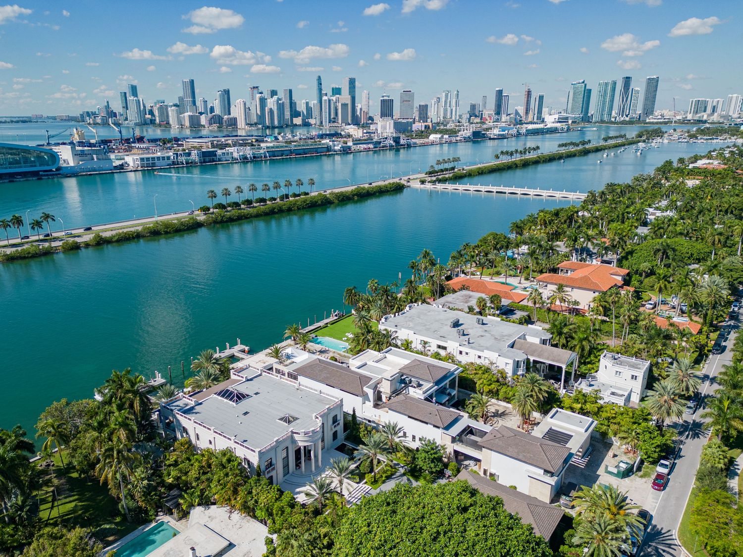 Aerial panoramic view of Miami skyline and waterfront luxury homes along Biscayne Bay.