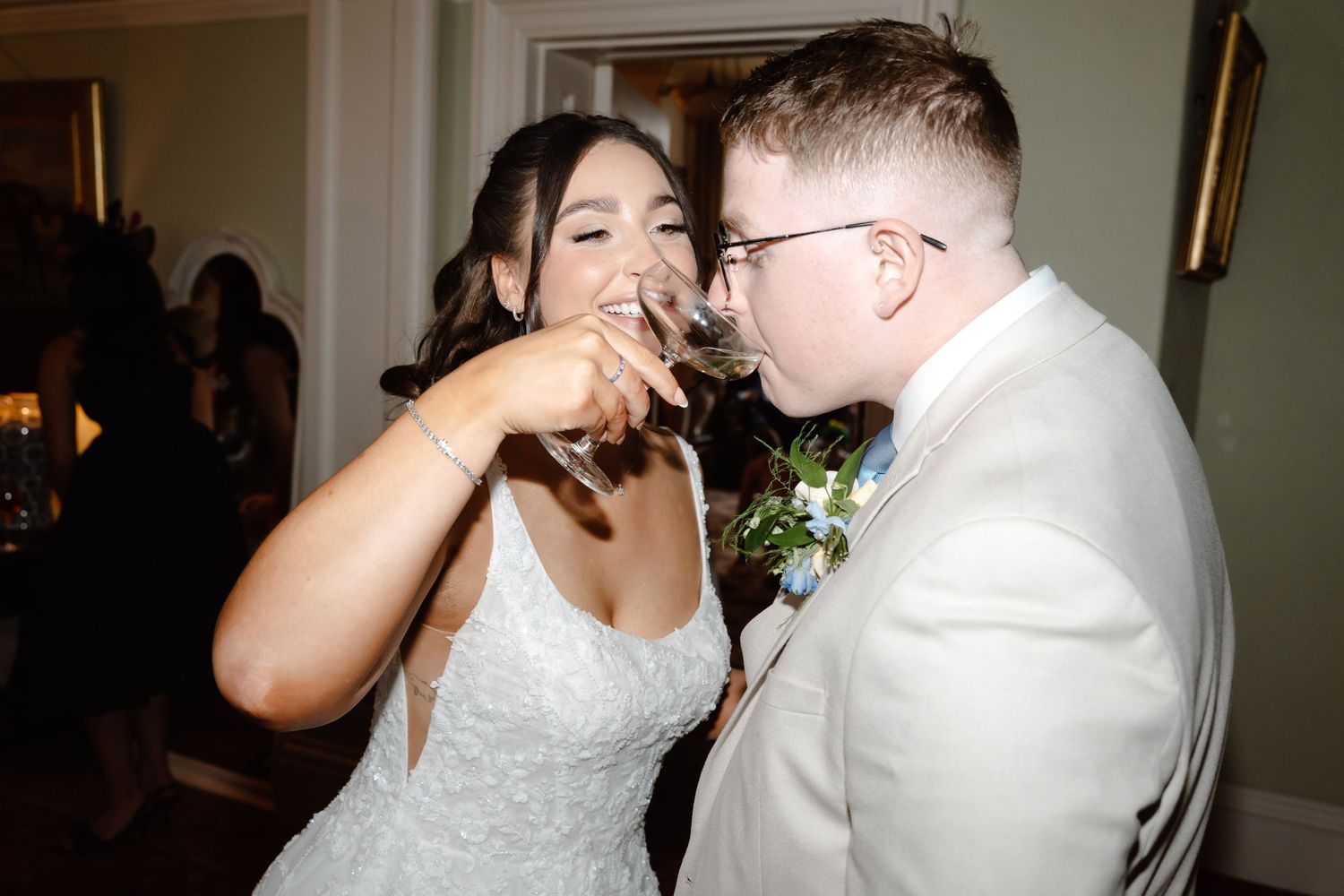Bride and groom sharing a drink together at their wedding reception celebration.