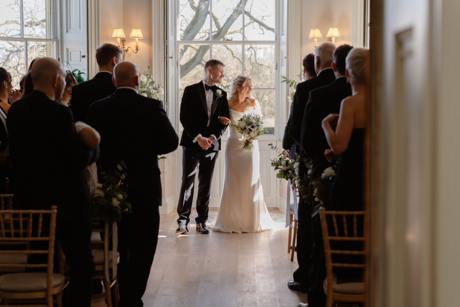 Bride and groom stand together at the altar during their elegant indoor wedding ceremony.