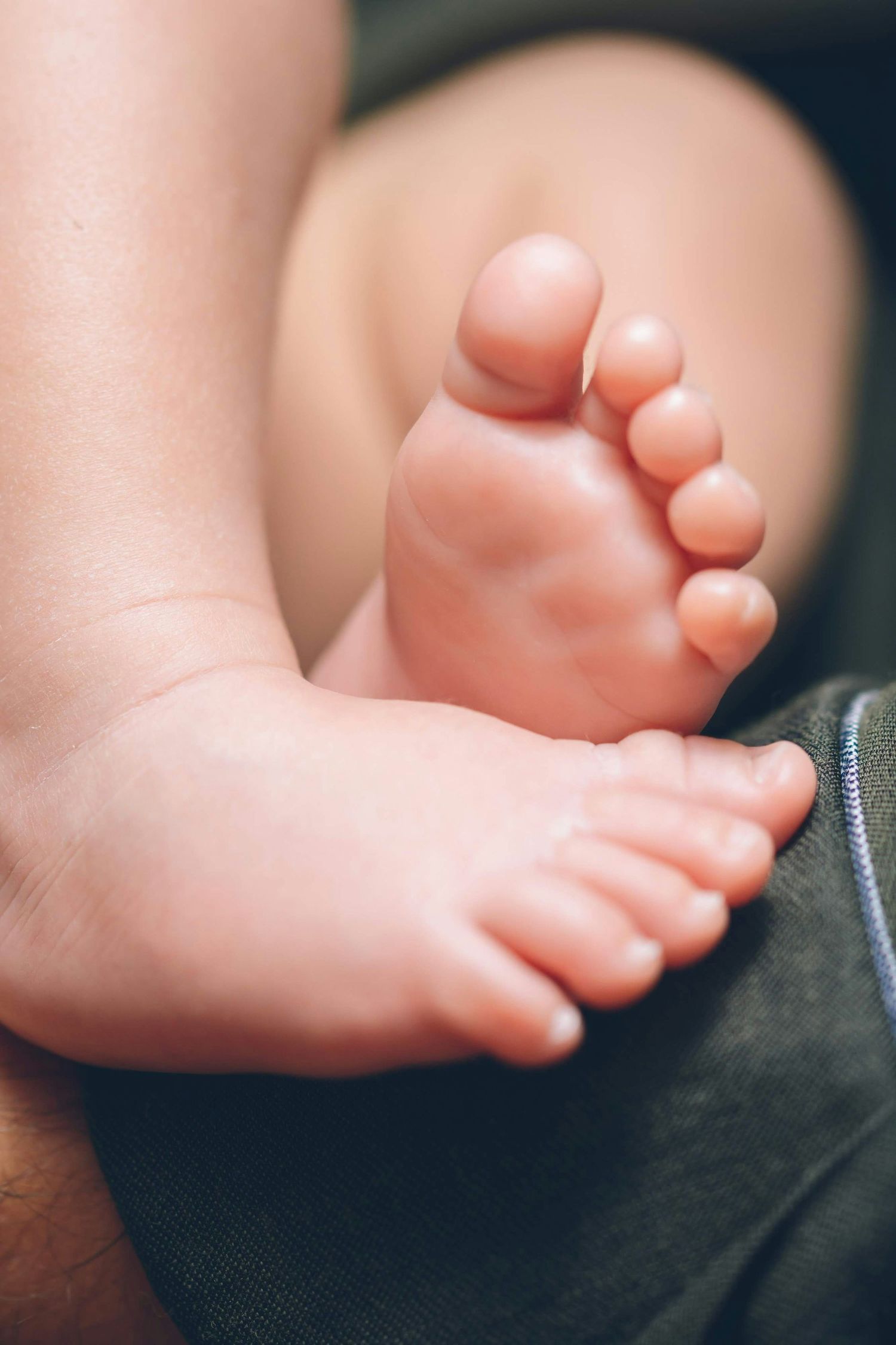Macro shot of tiny newborn baby feet with delicate toes in focus.