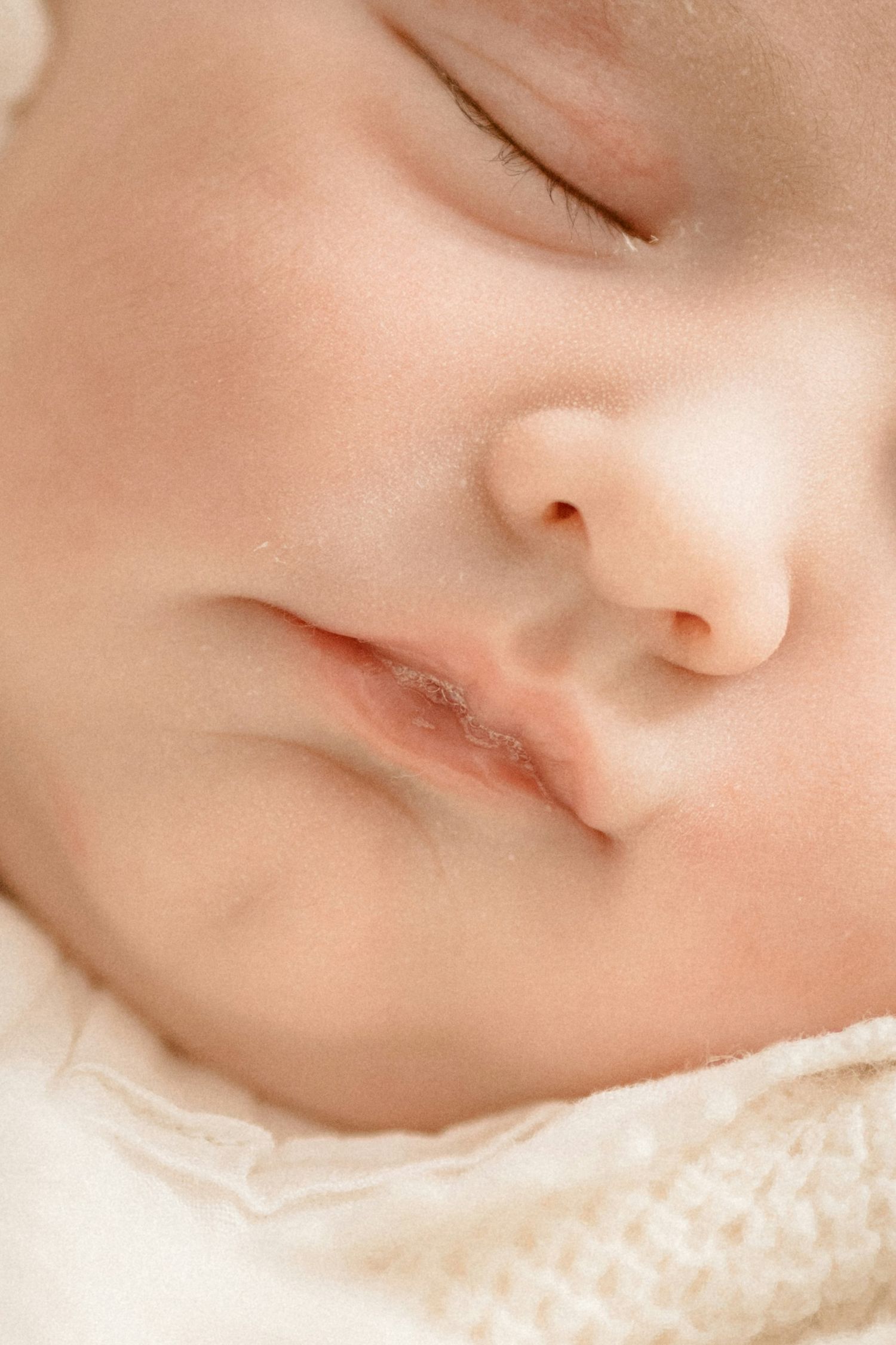 Close-up of peaceful sleeping newborn baby face with soft skin.