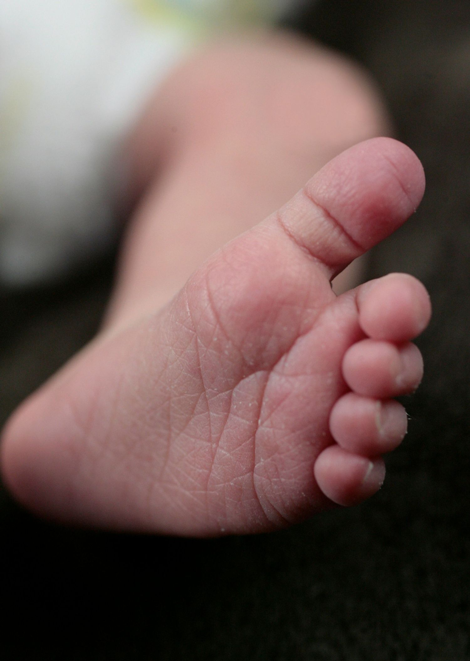 Extreme close-up macro shot of a newborn baby foot showing delicate skin texture.