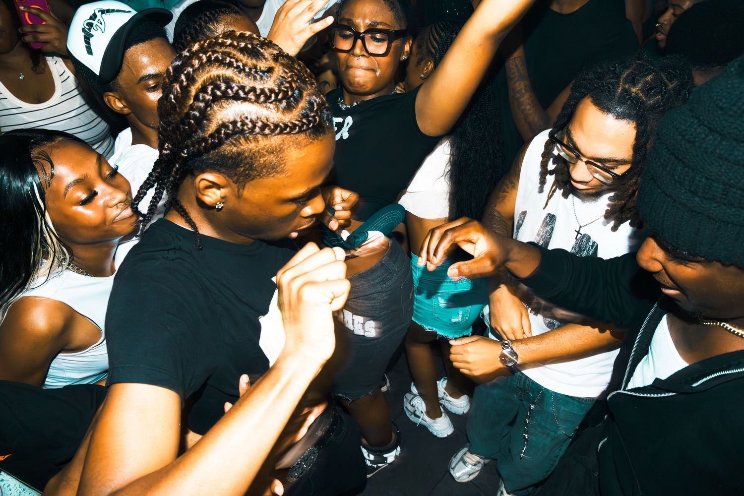 Group of young people dancing and socializing at a lively indoor party event.