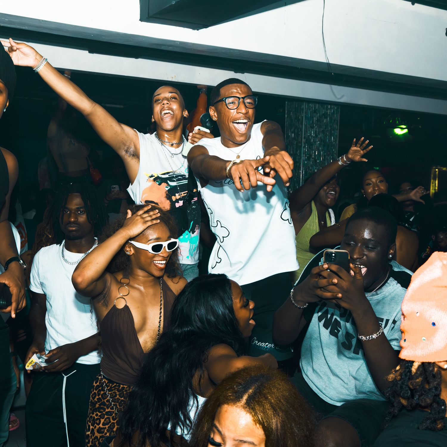 Energetic crowd dancing and celebrating at a lively indoor party event.
