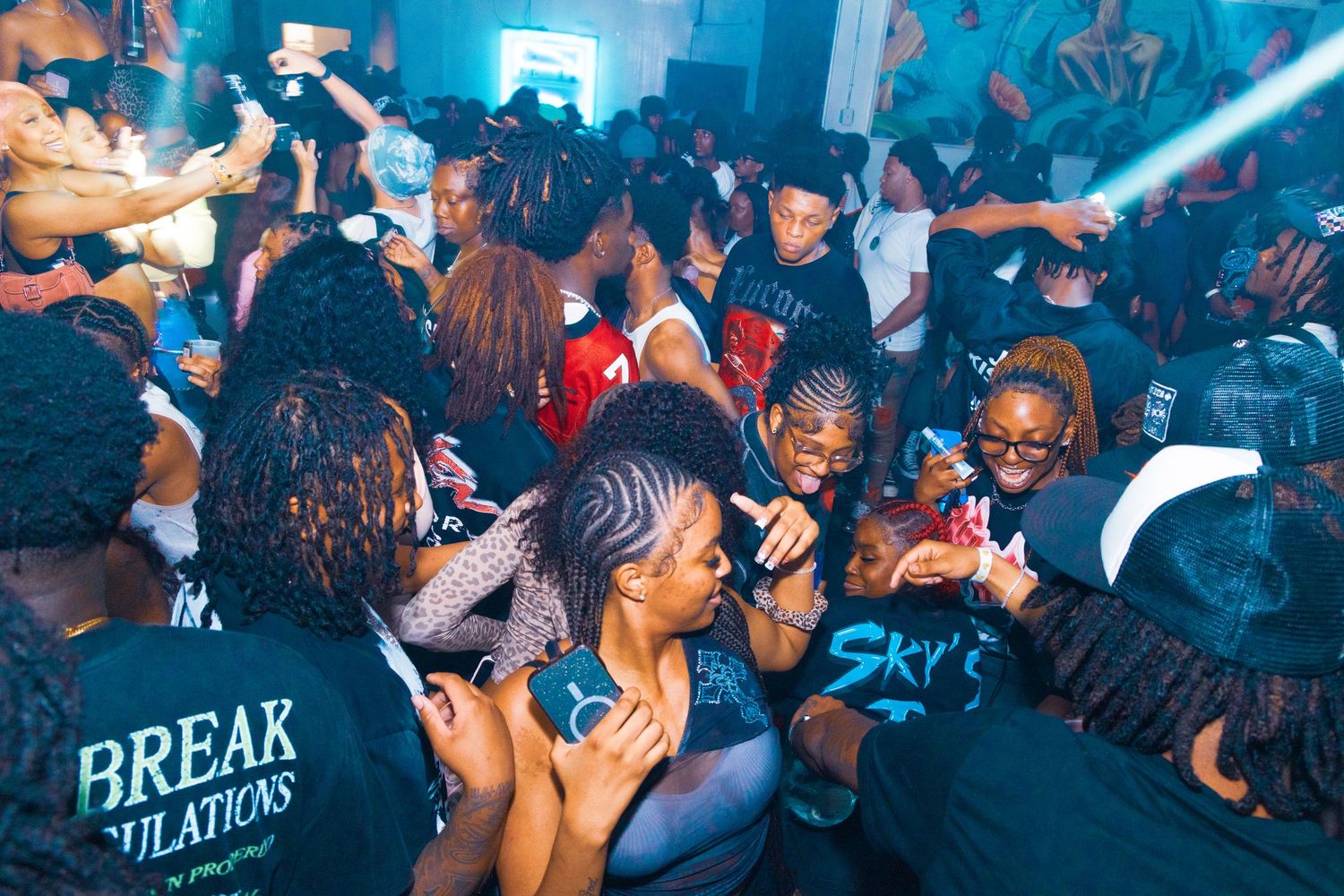 Energetic nightclub crowd dancing and socializing at a lively indoor party event.