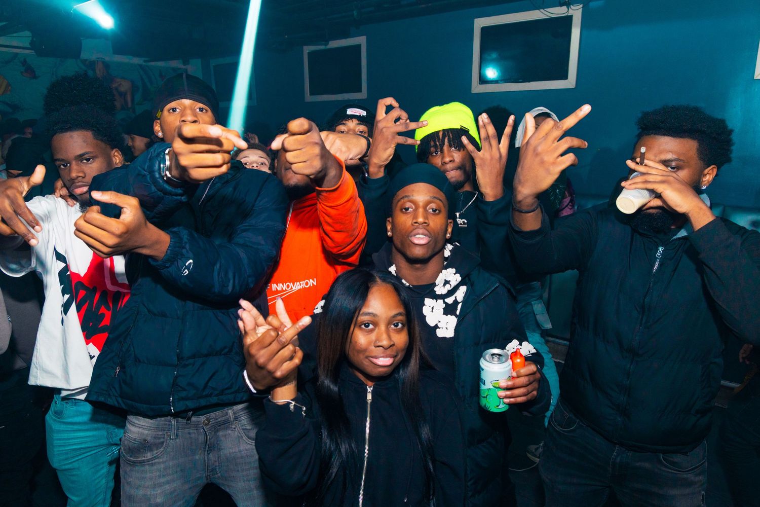 Group of young people posing and smiling together at an indoor party event.