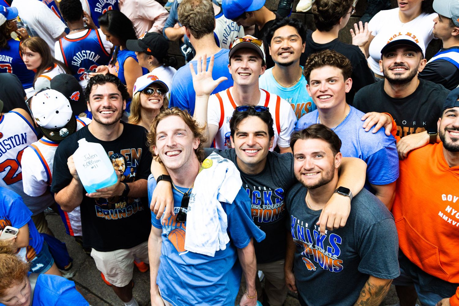 Group of young men smiling and posing together at a lively outdoor sports celebration event.