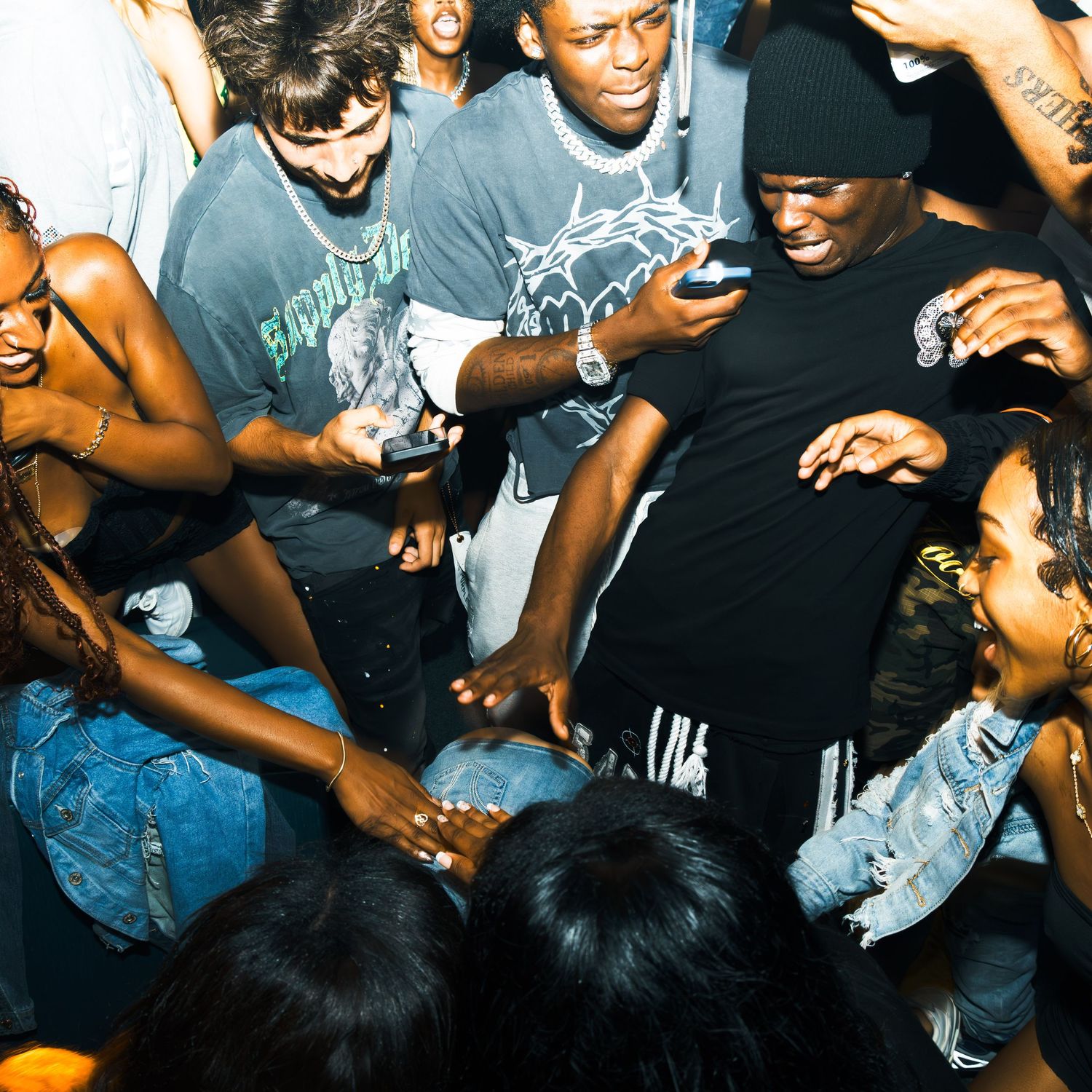 A lively crowd of young people dancing together at an energetic nightclub party.