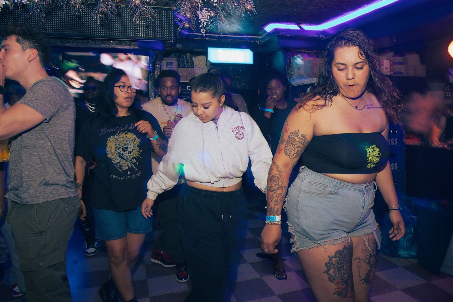 Group of people dancing together at a casual indoor bar or club event.