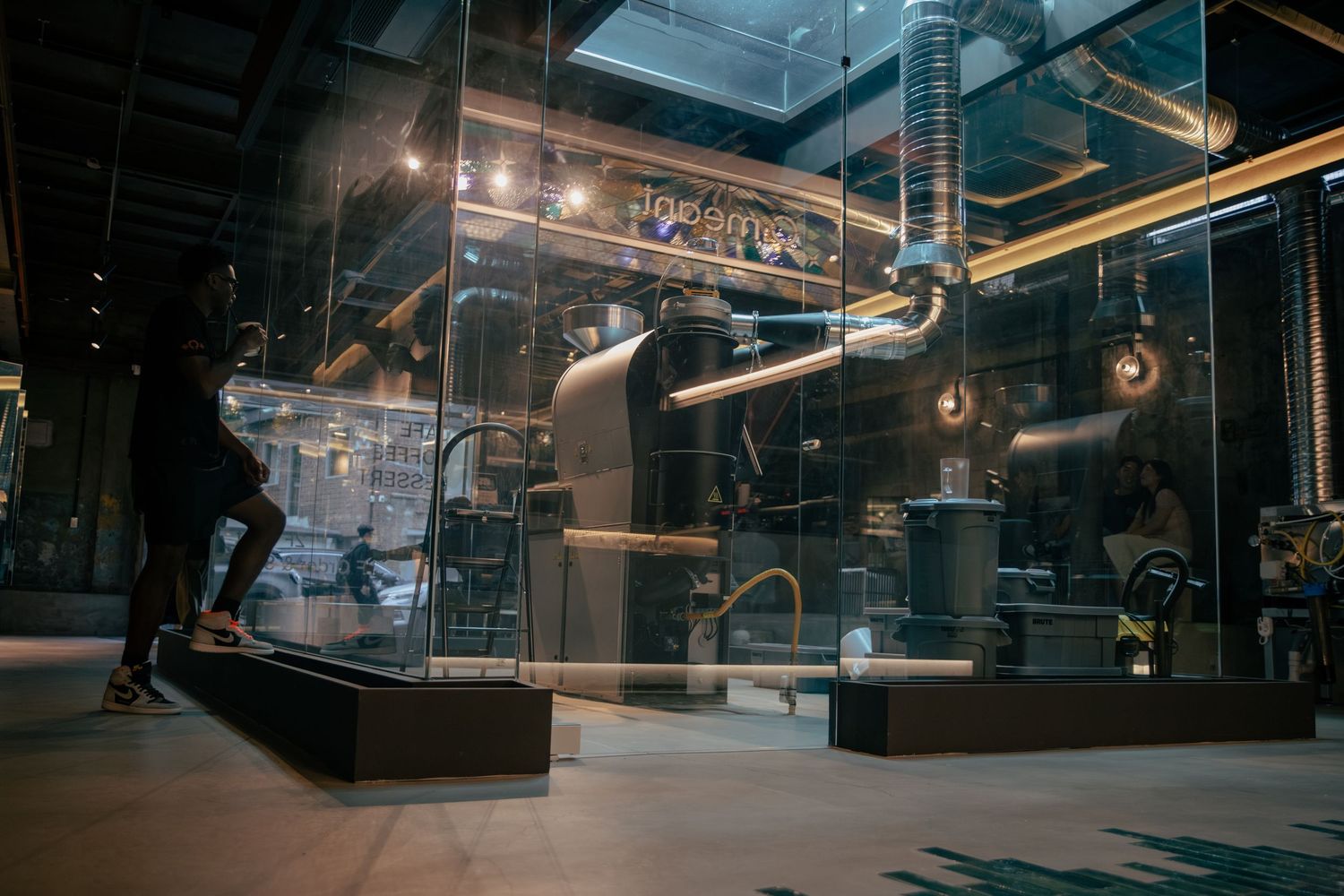 Industrial steampunk interior with glass enclosures, pipes, and ambient lighting in a modern exhibition space.