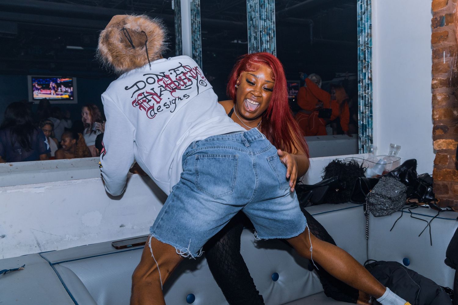 Two women dancing together at a lively nightclub party event.