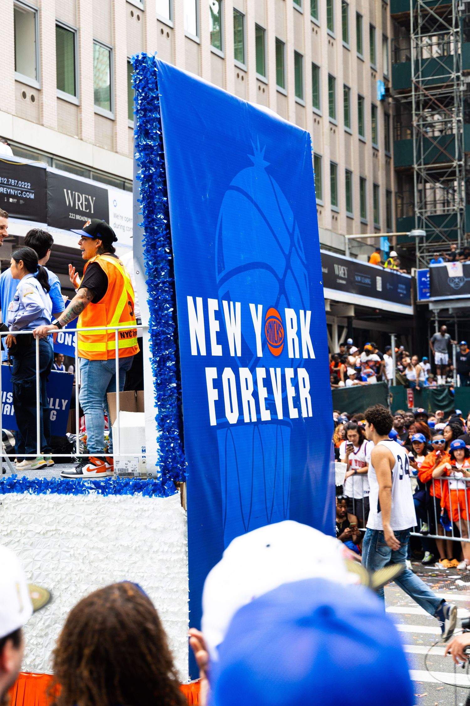 New York Forever banner on a blue parade float during a New York City street parade.