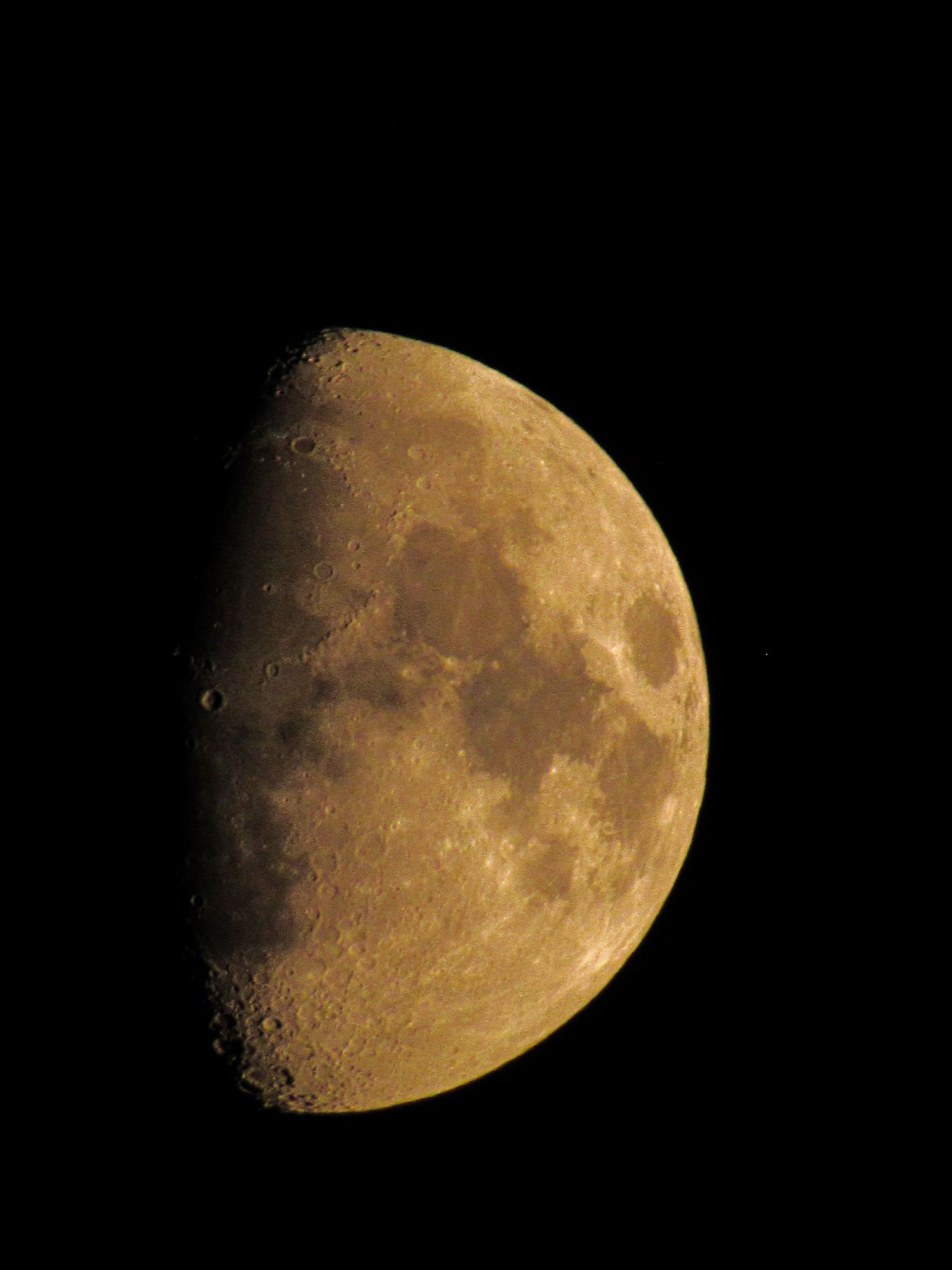 Detailed view of a waxing gibbous moon showing its craters and surface features against a black sky.