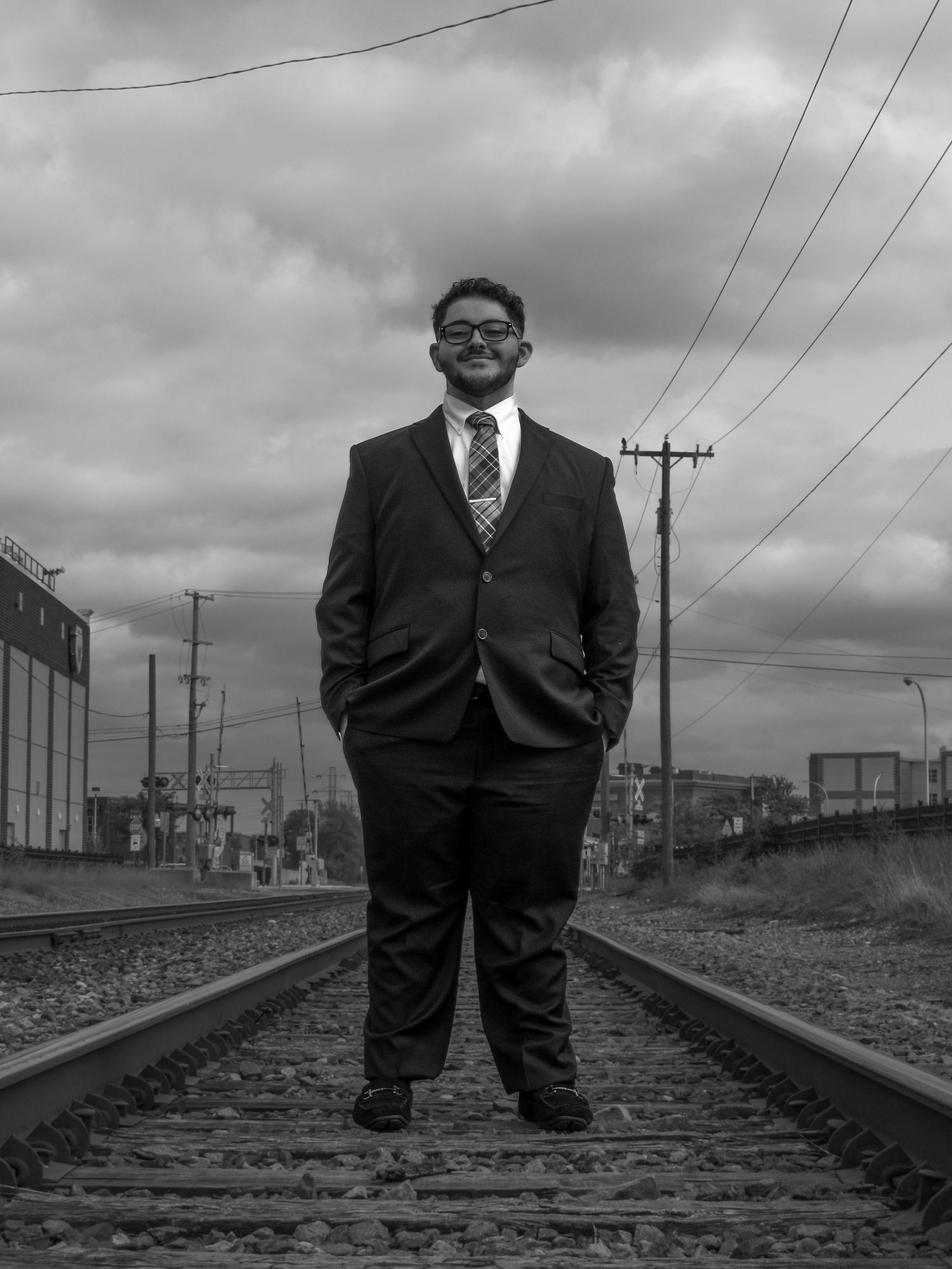 Black and white series of poses on railroad tracks with a downtown view.