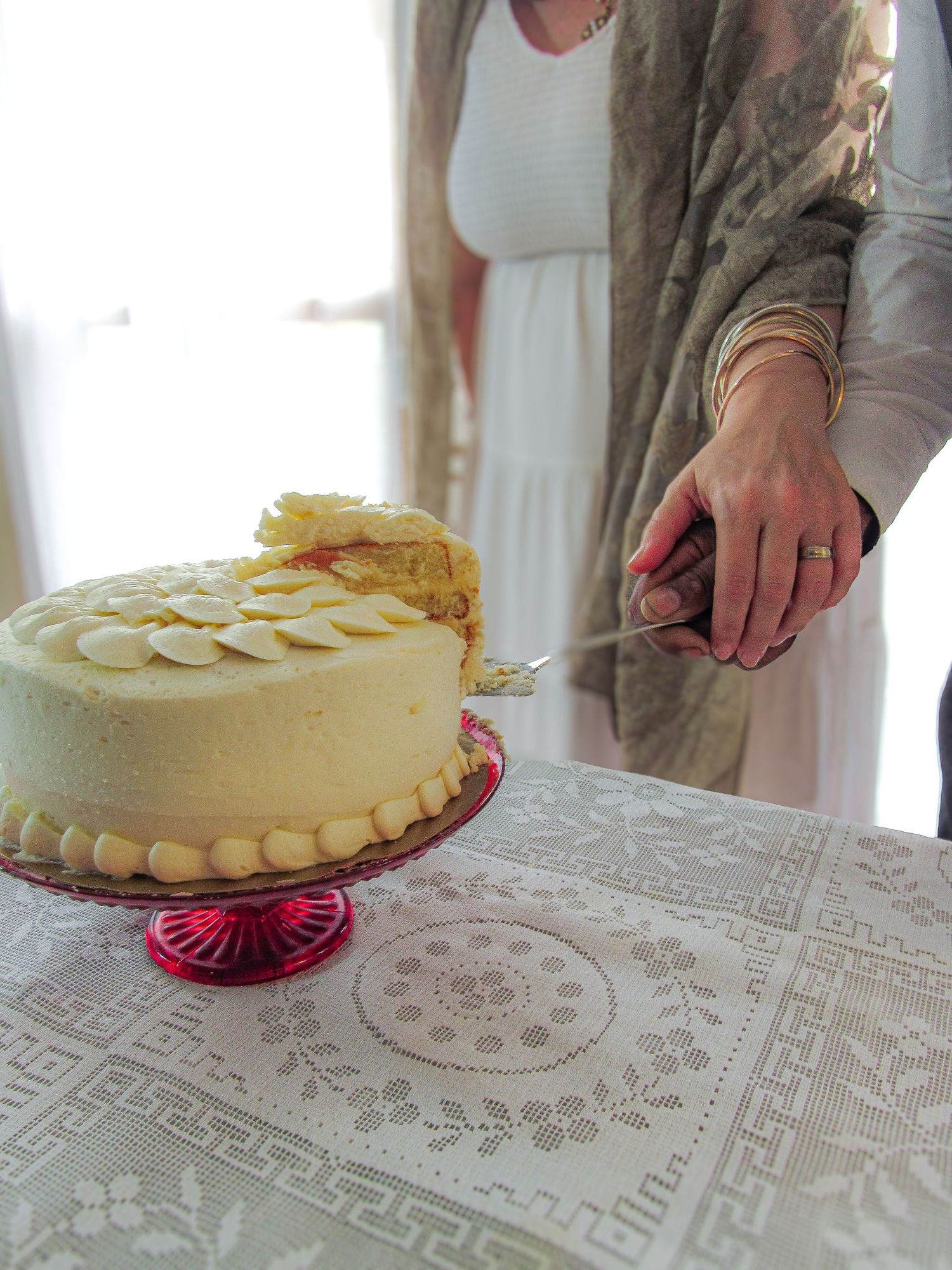 A series of images showing hands cutting a cake on a lace tablecloth in sequence.