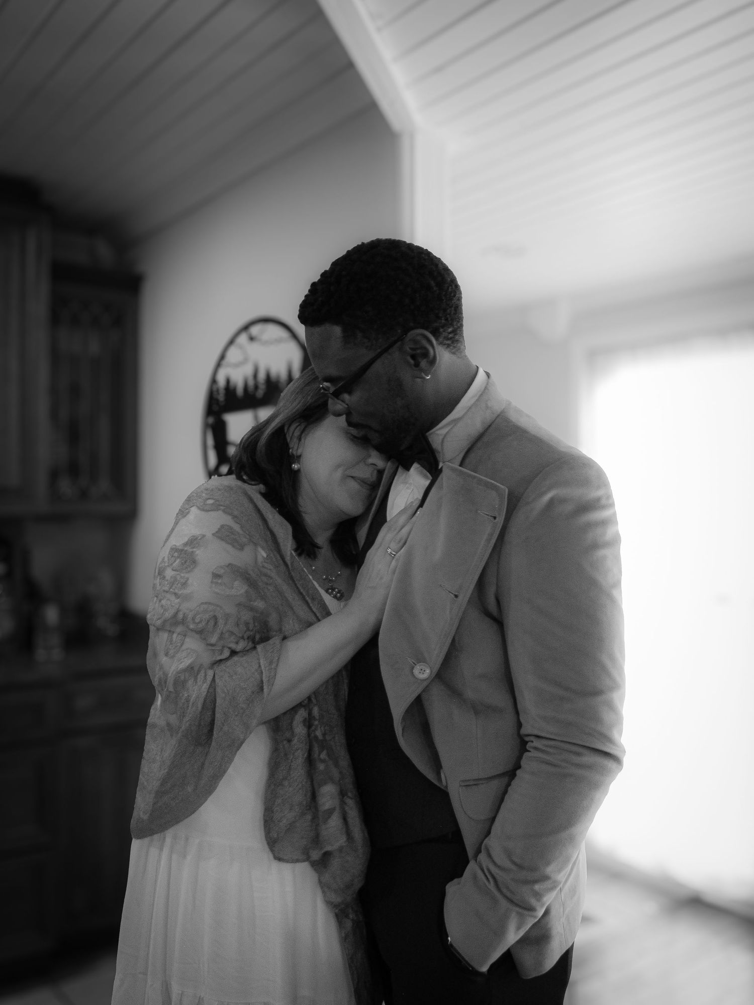 Artistic black and white photo series capturing tender moments in a bright interior space.