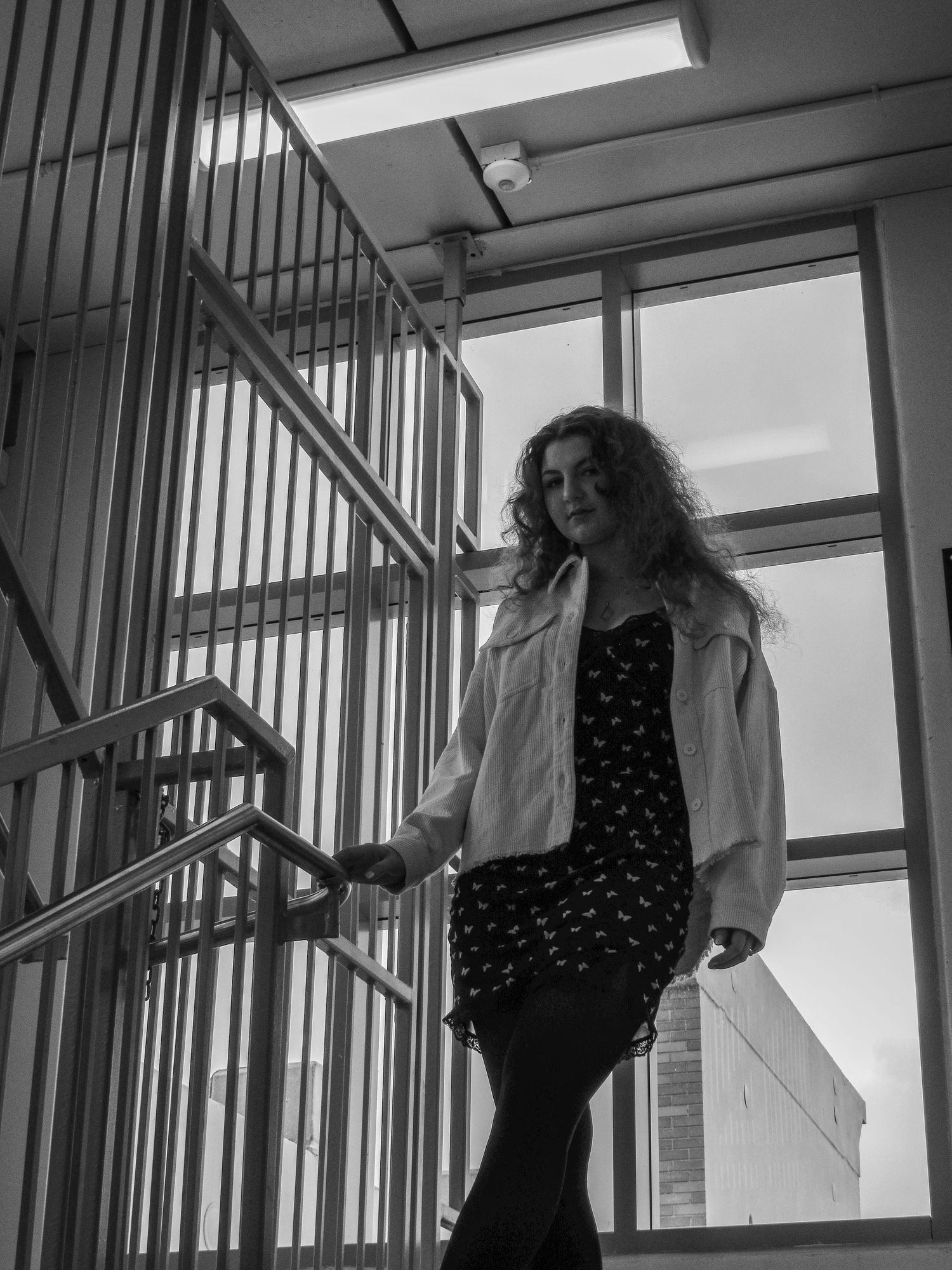Dramatic black and white stairwell photoshoot with artistic poses.