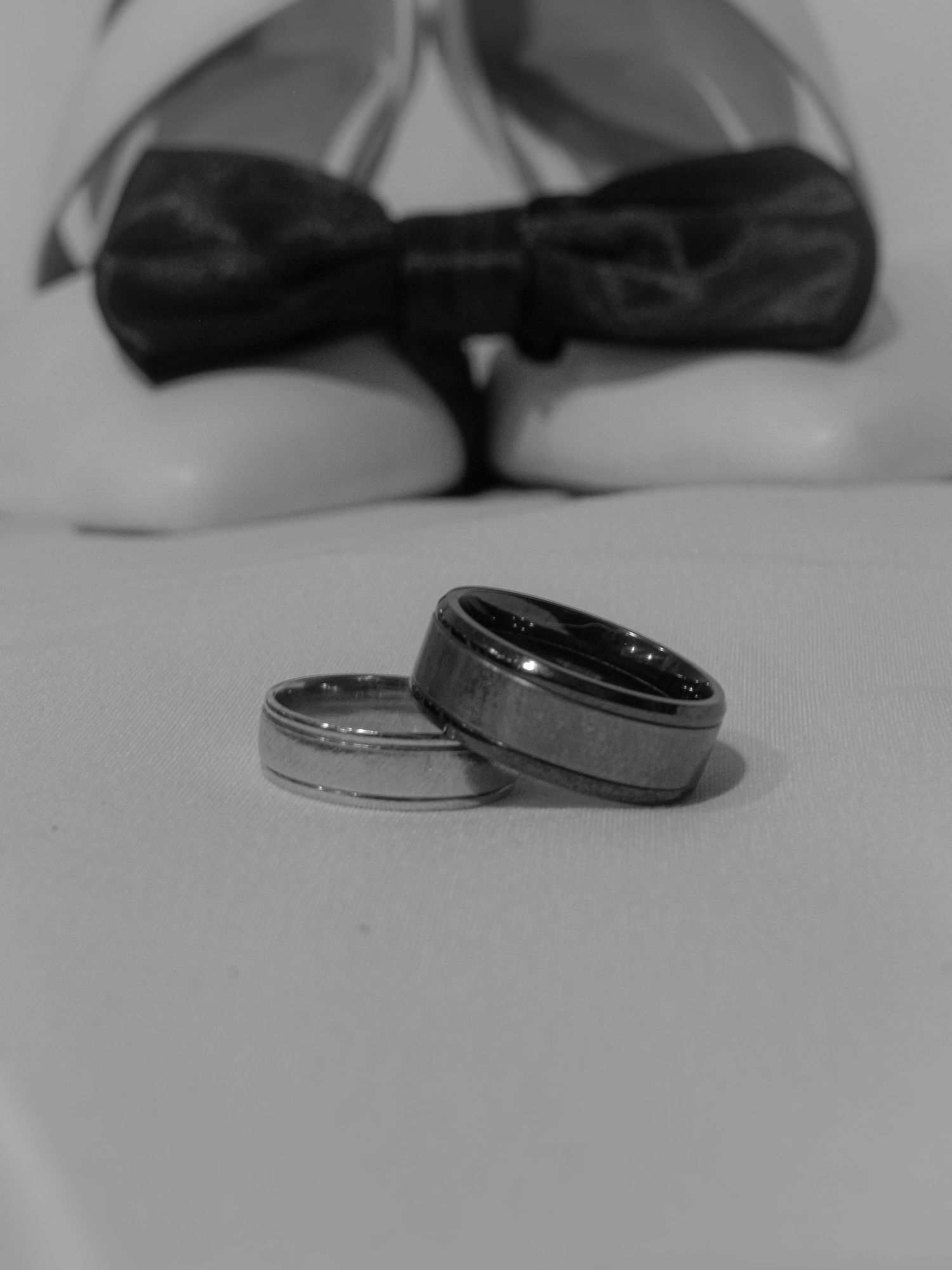 A series of black and white close-up photographs showing wedding rings in various compositions.