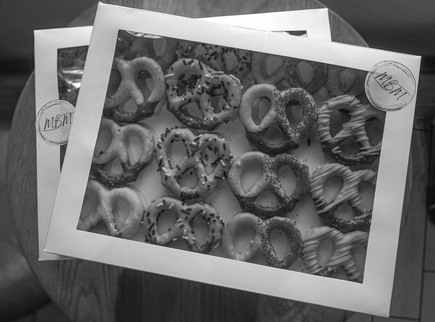 Black and white photograph showing overlapping vintage photo prints displaying seashells arranged in a pattern.