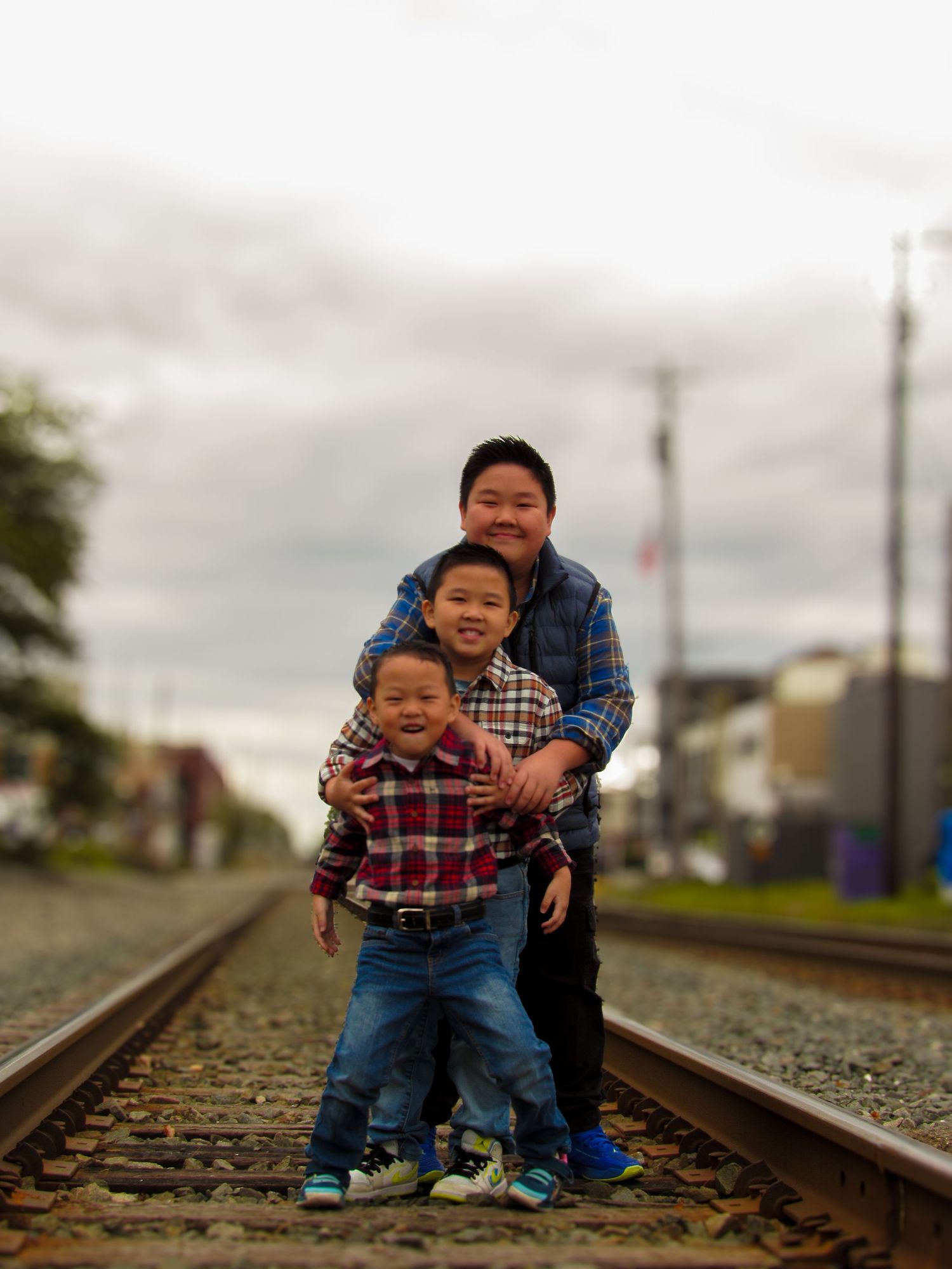 A sequence of playful photos taken on railroad tracks on an overcast day.