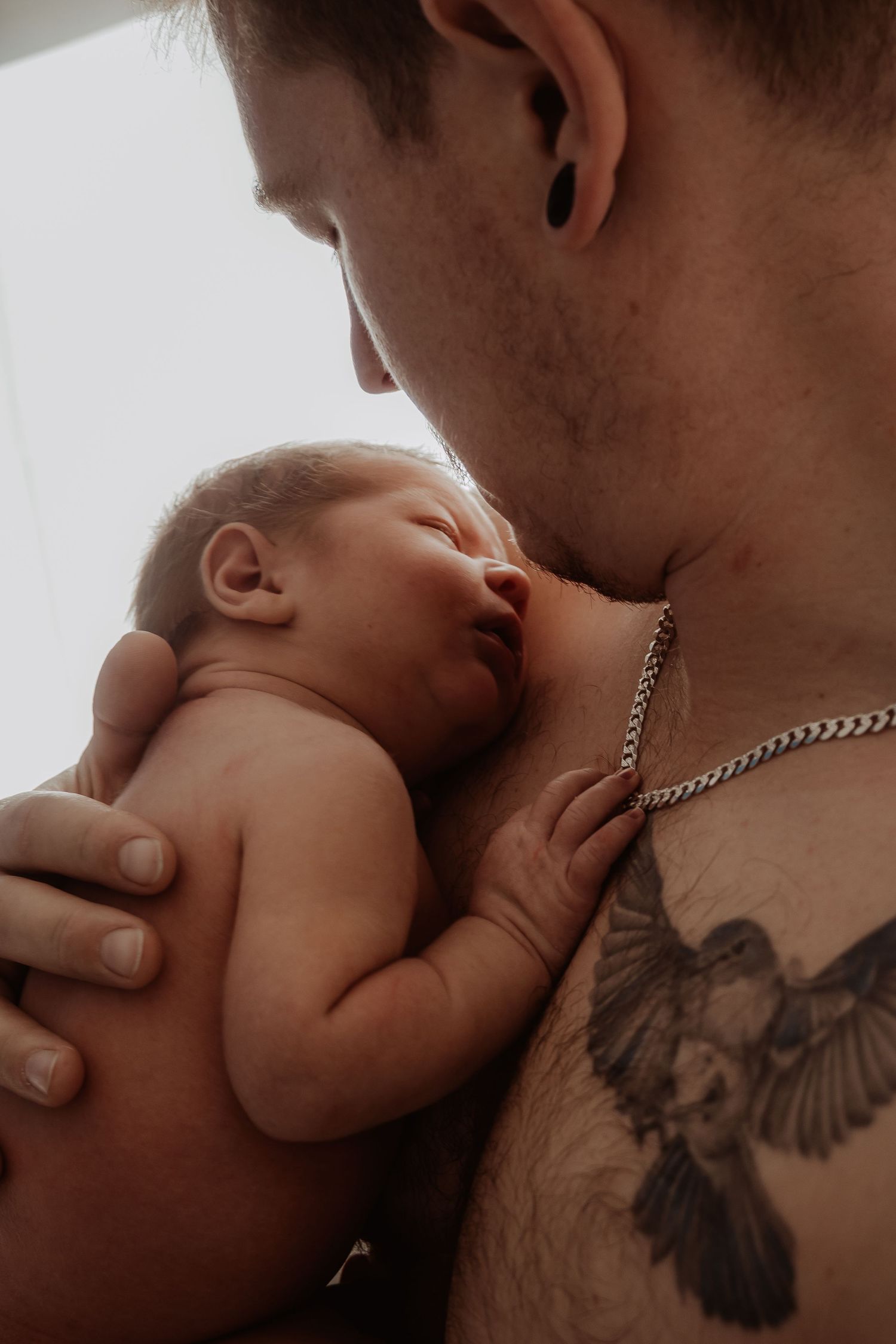 Father enjoying their newborn in a skin-to-skin moment at a central coast newborn photoshoot.
