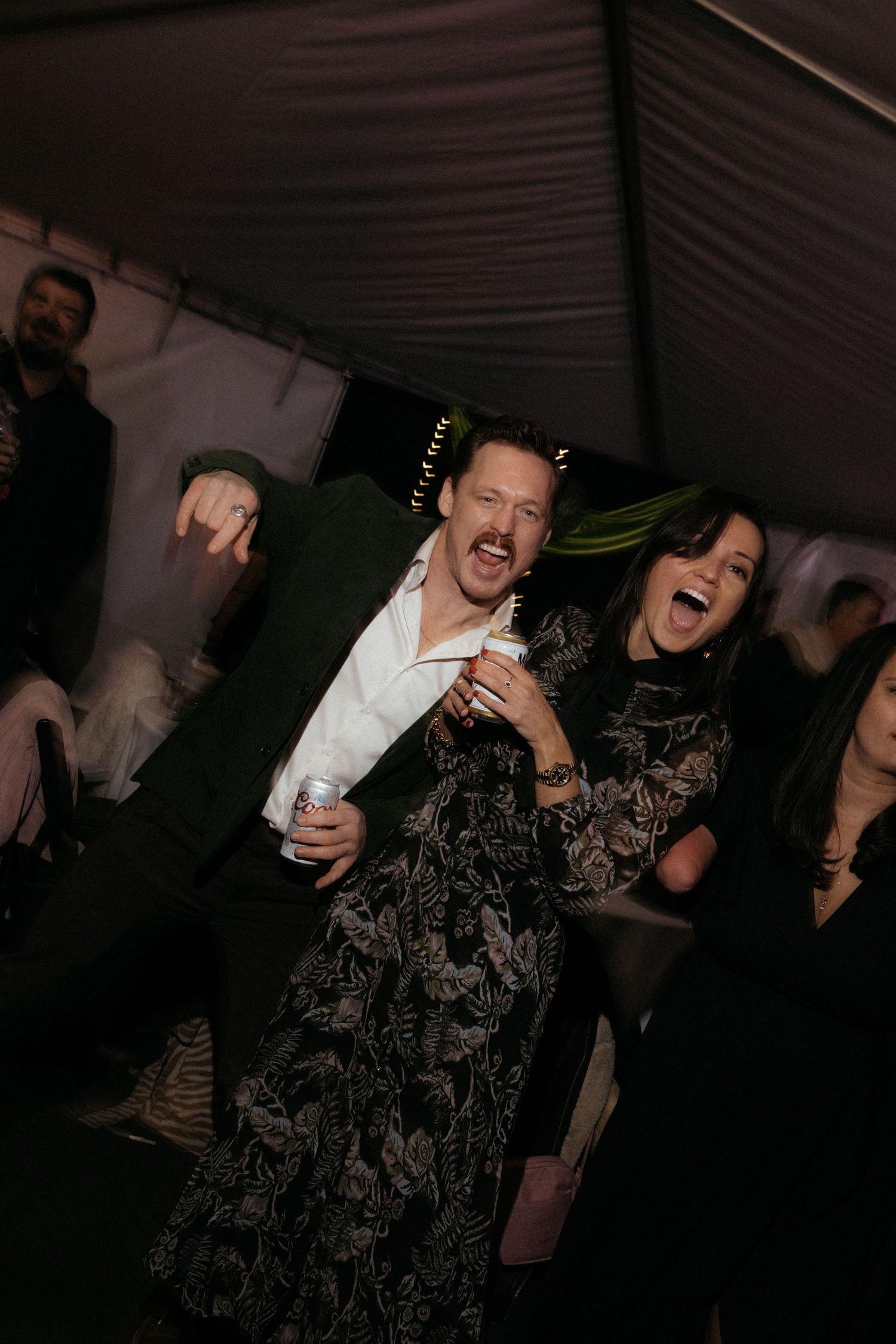 Guests dancing and laughing together at a lively indoor celebration.