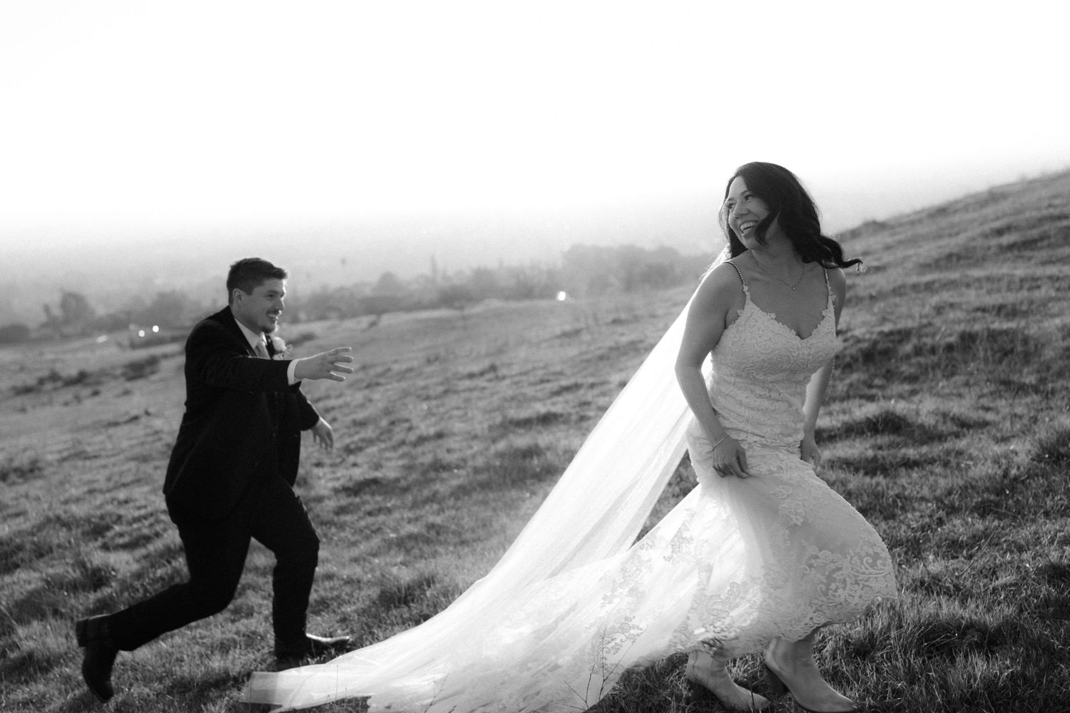 A series of romantic black and white wedding photos showing a couple posing together on a hillside landscape.