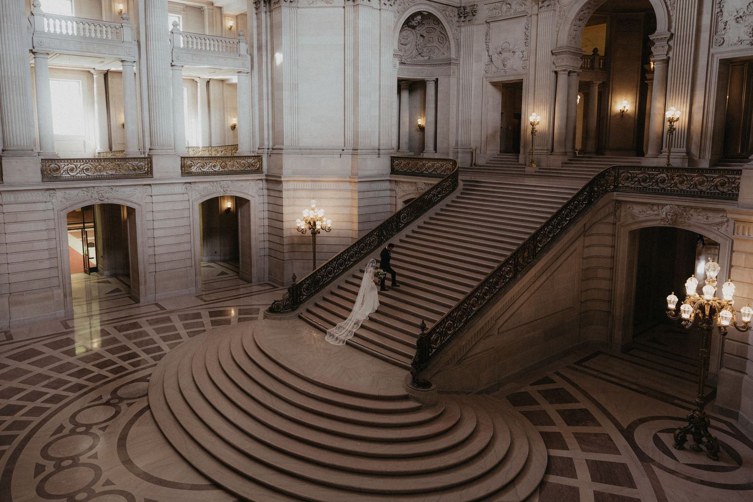 Grand staircase and interior architecture of a historic building with elegant lighting.