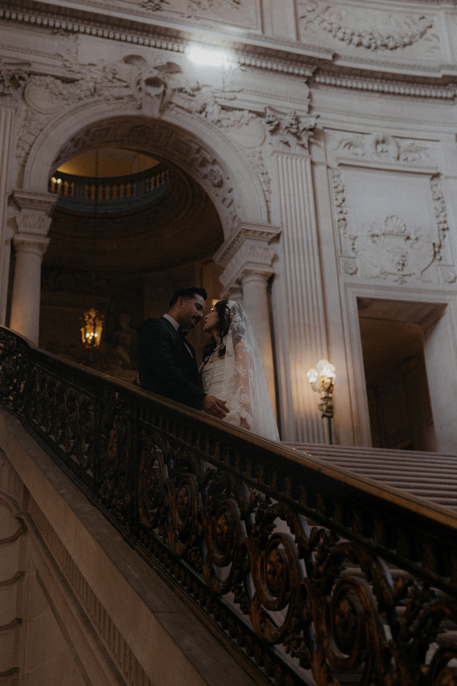 Dramatic view of an ornate staircase with decorative railings in a historic building.