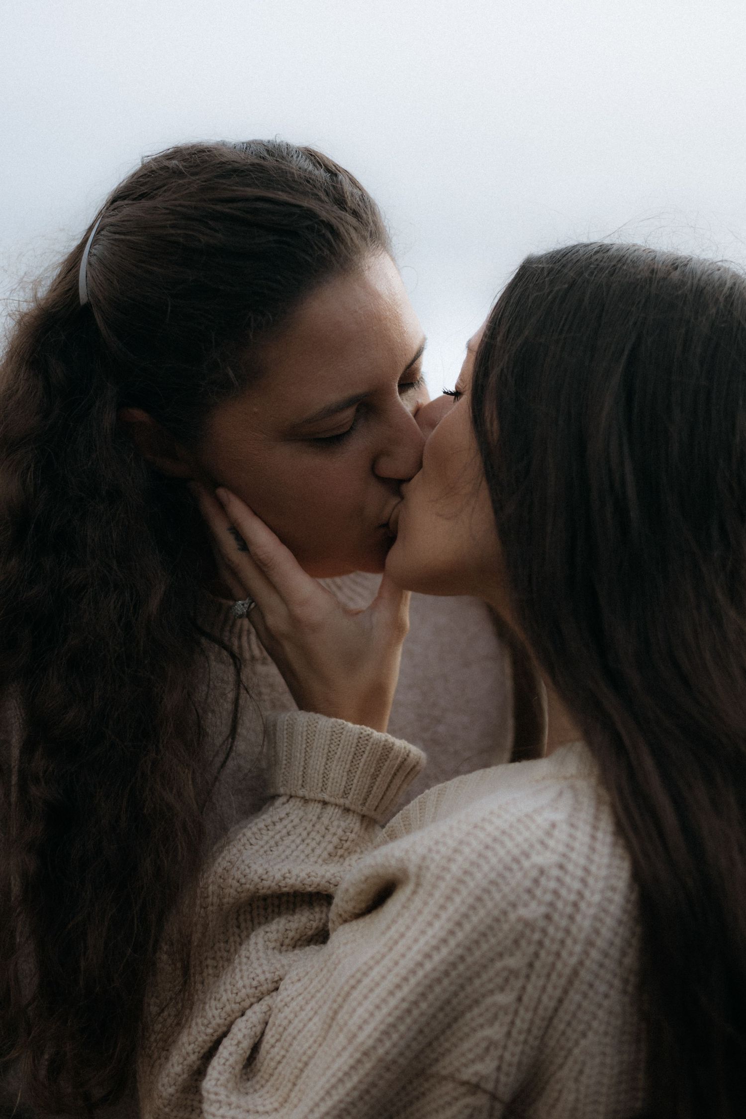 A romantic couple sharing intimate moments in a series of close-up shots wearing cozy knit sweaters.