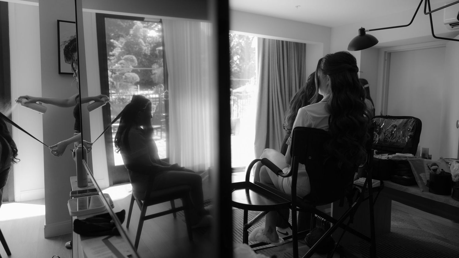 Black and white panoramic sequence showing a person sitting at a desk in front of computer monitors in a home office.