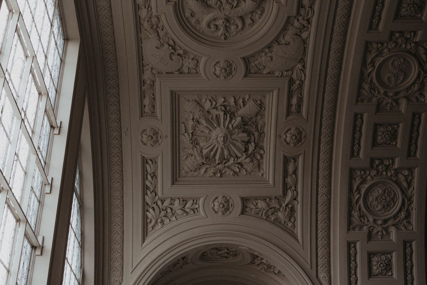 Ornate classical ceiling with detailed carved moldings and decorative patterns.