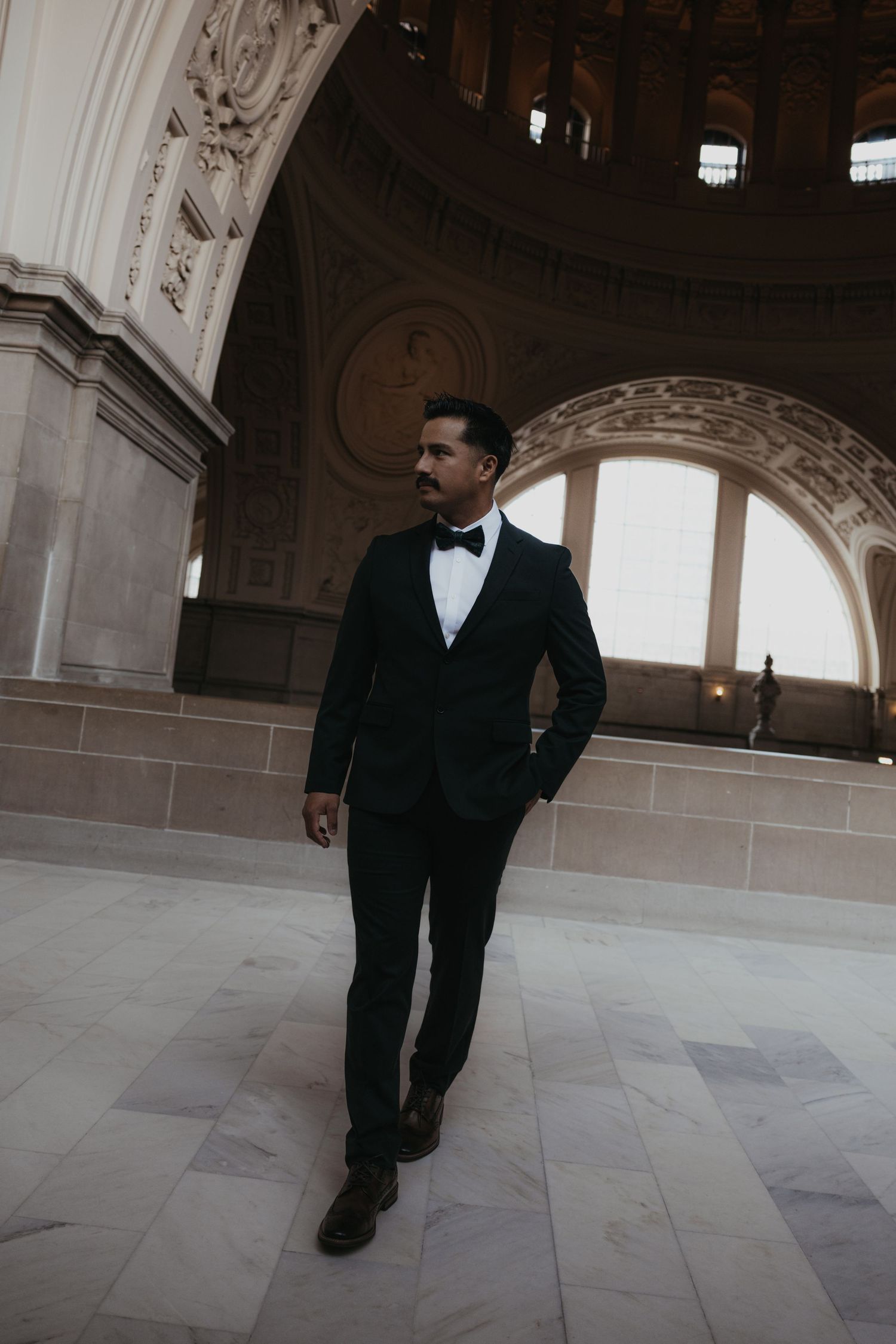 A formal portrait session in a grand marble hallway with ornate architectural details.