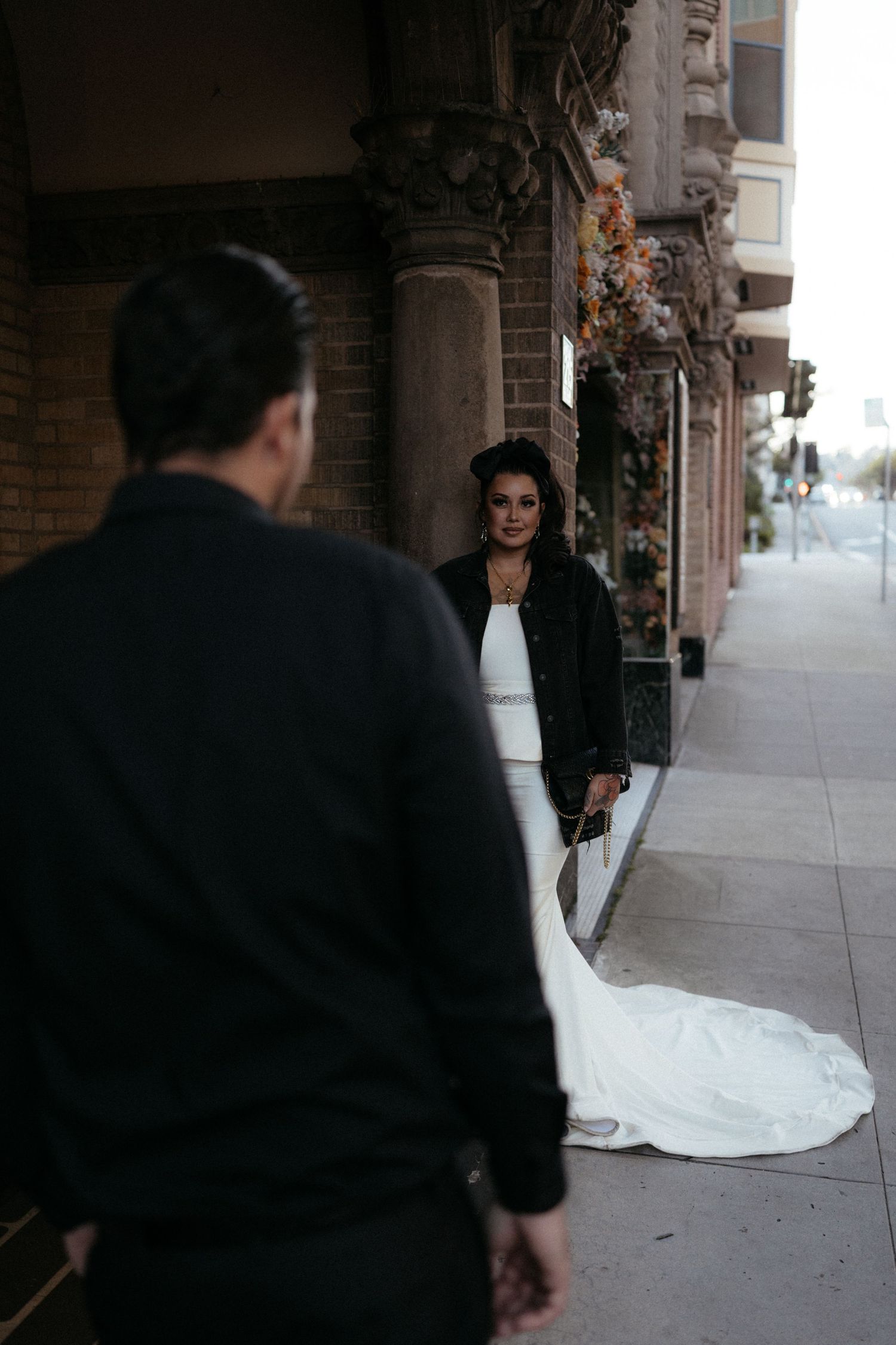 Wedding photography session outside brick building with dramatic lighting.
