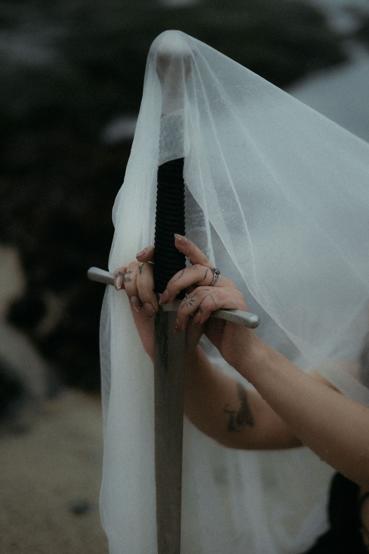 Close-up sequence of hands carefully adjusting delicate white wedding veil fabric against dark background.
