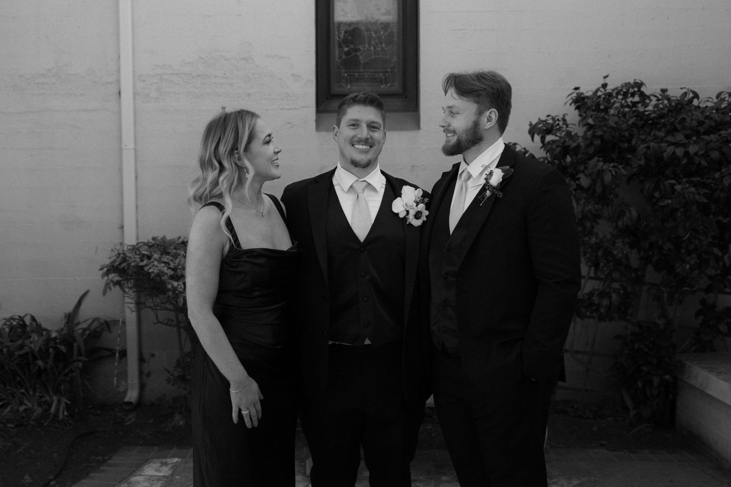 A series of black and white wedding photos showing intimate moments between a couple at their celebration.