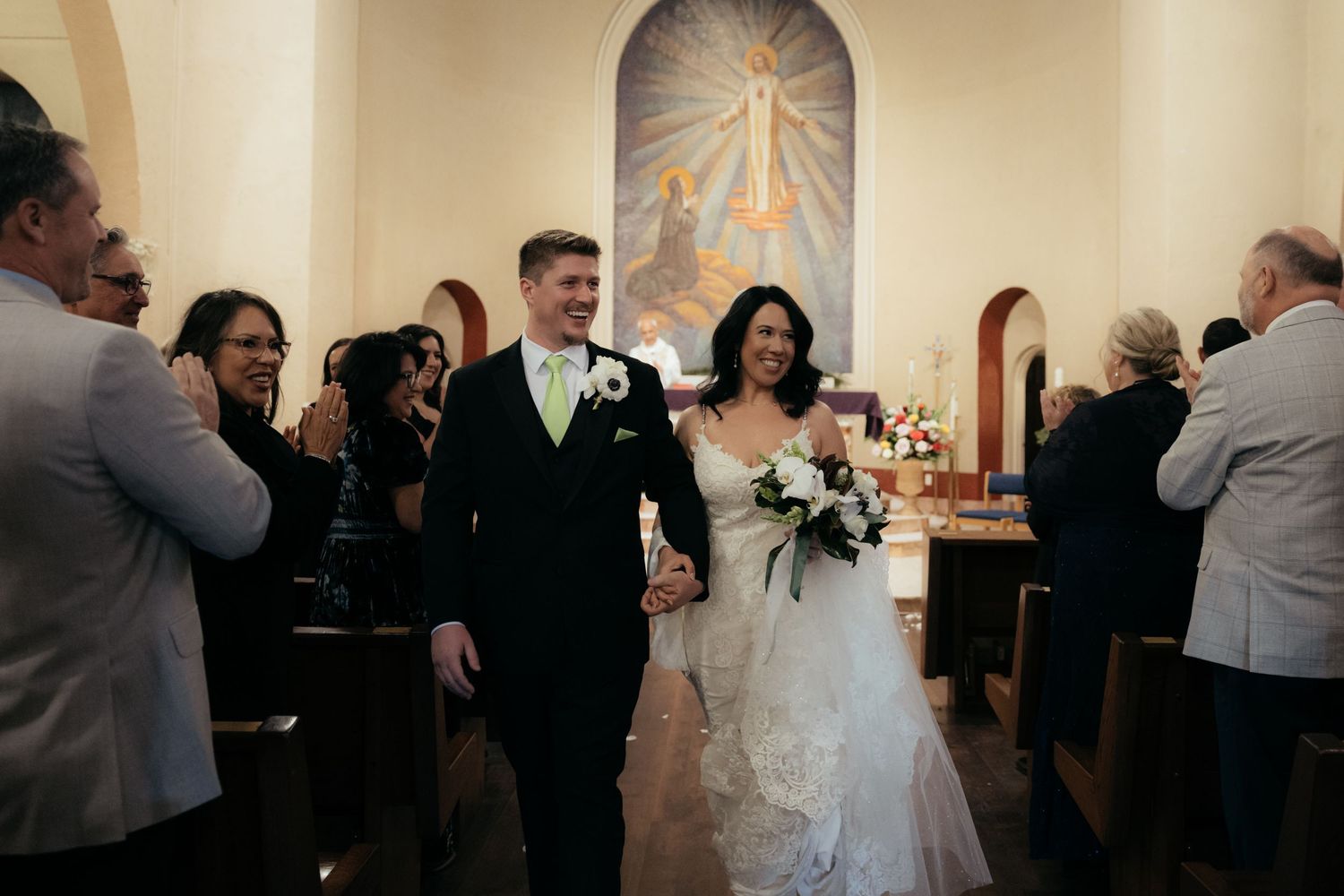 Newlyweds walk down the church aisle as guests celebrate their union.