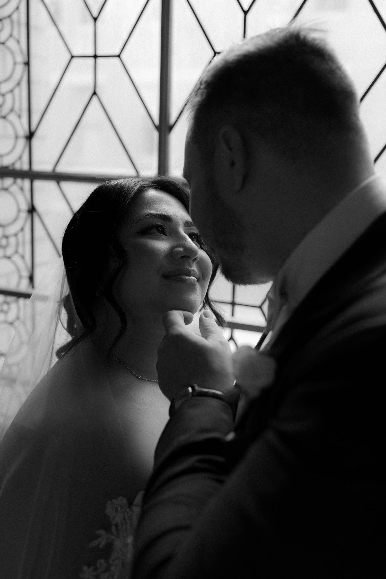A series of black and white romantic photos showing a couple in silhouette against a window with geometric patterns.
