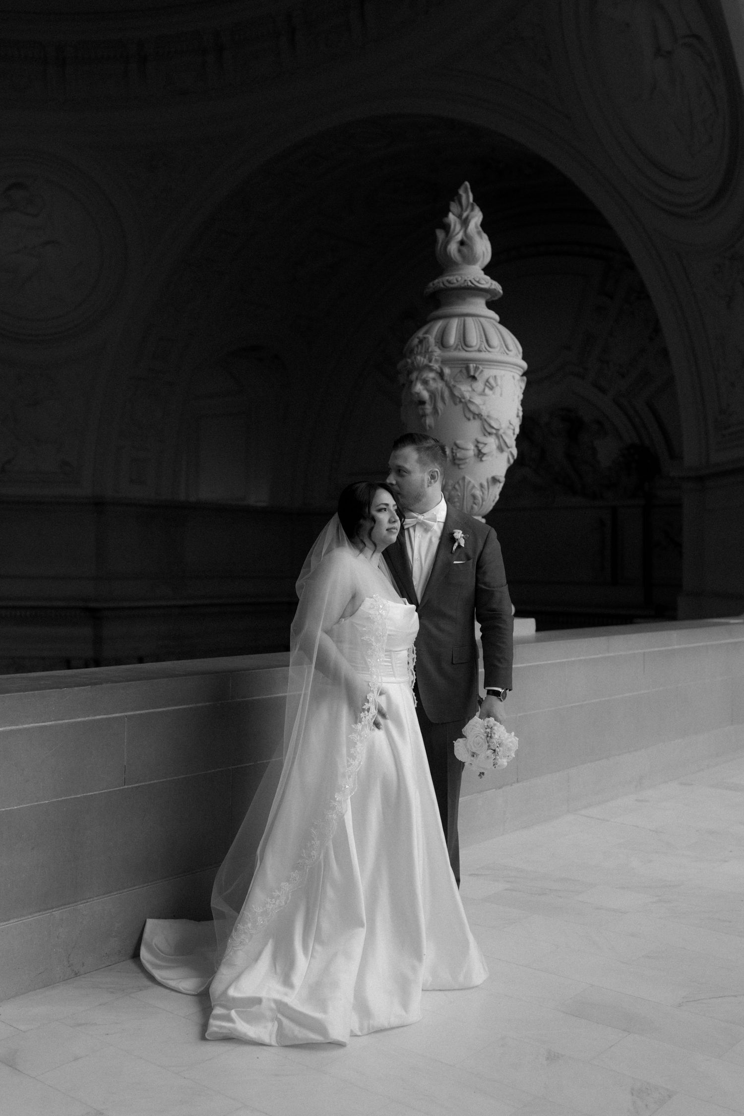 A black and white wedding photo sequence showing a couple dancing in a grand ballroom.