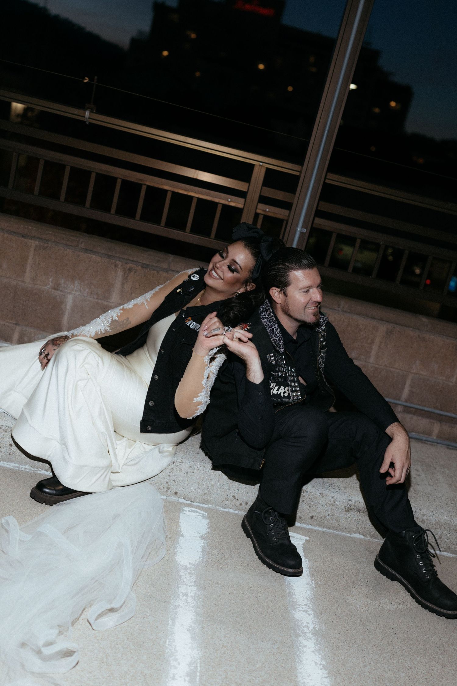 Sequence showing couple relaxing on floor in contrasting white dress and dark outfit.