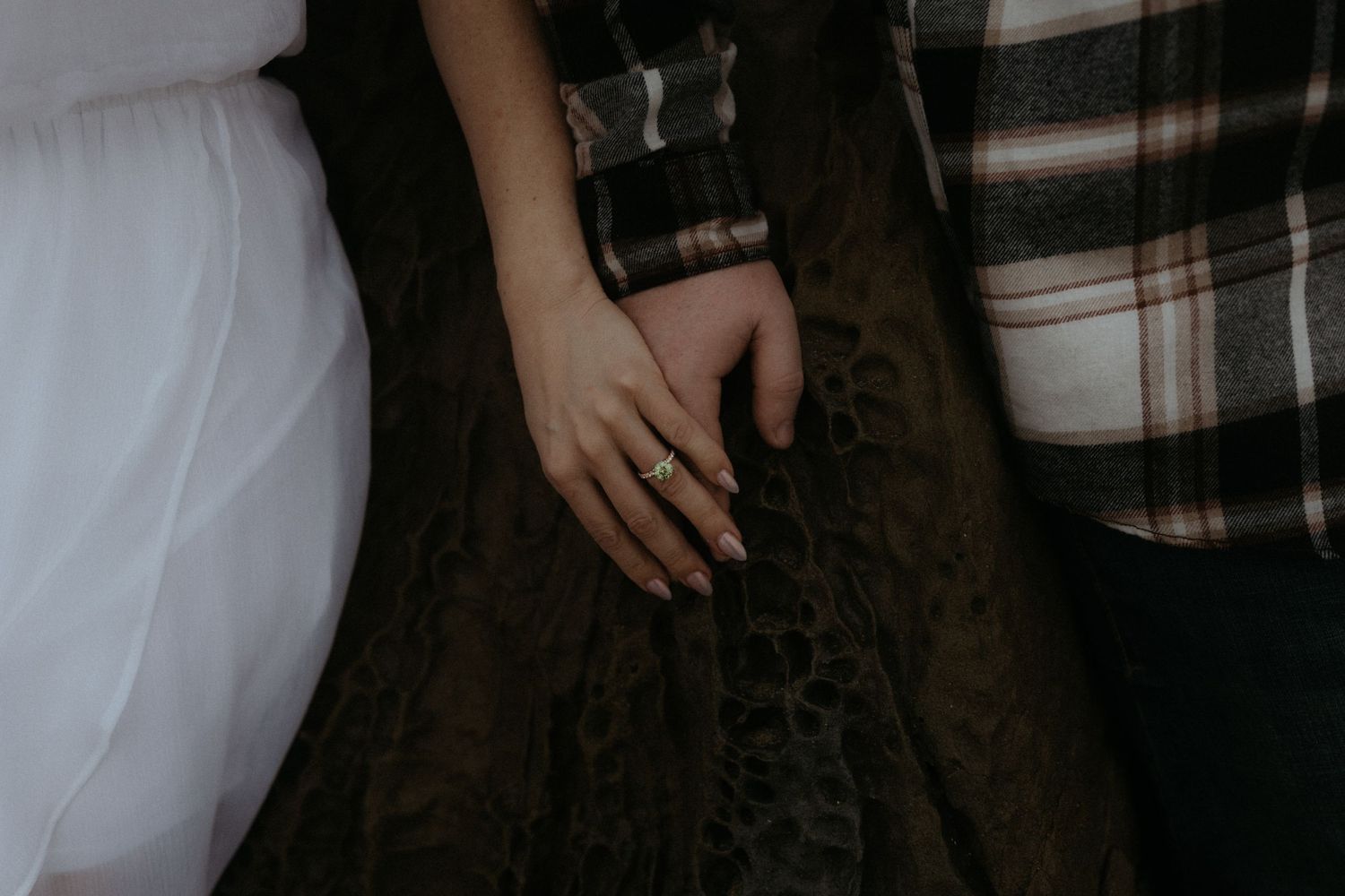 A romantic couple embraces in soft lighting during an intimate photoshoot.
