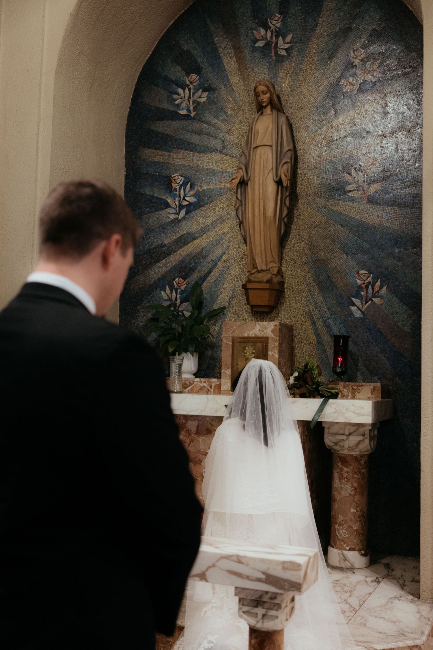 A church altar features a dramatic mosaic backdrop with religious imagery during a wedding ceremony.