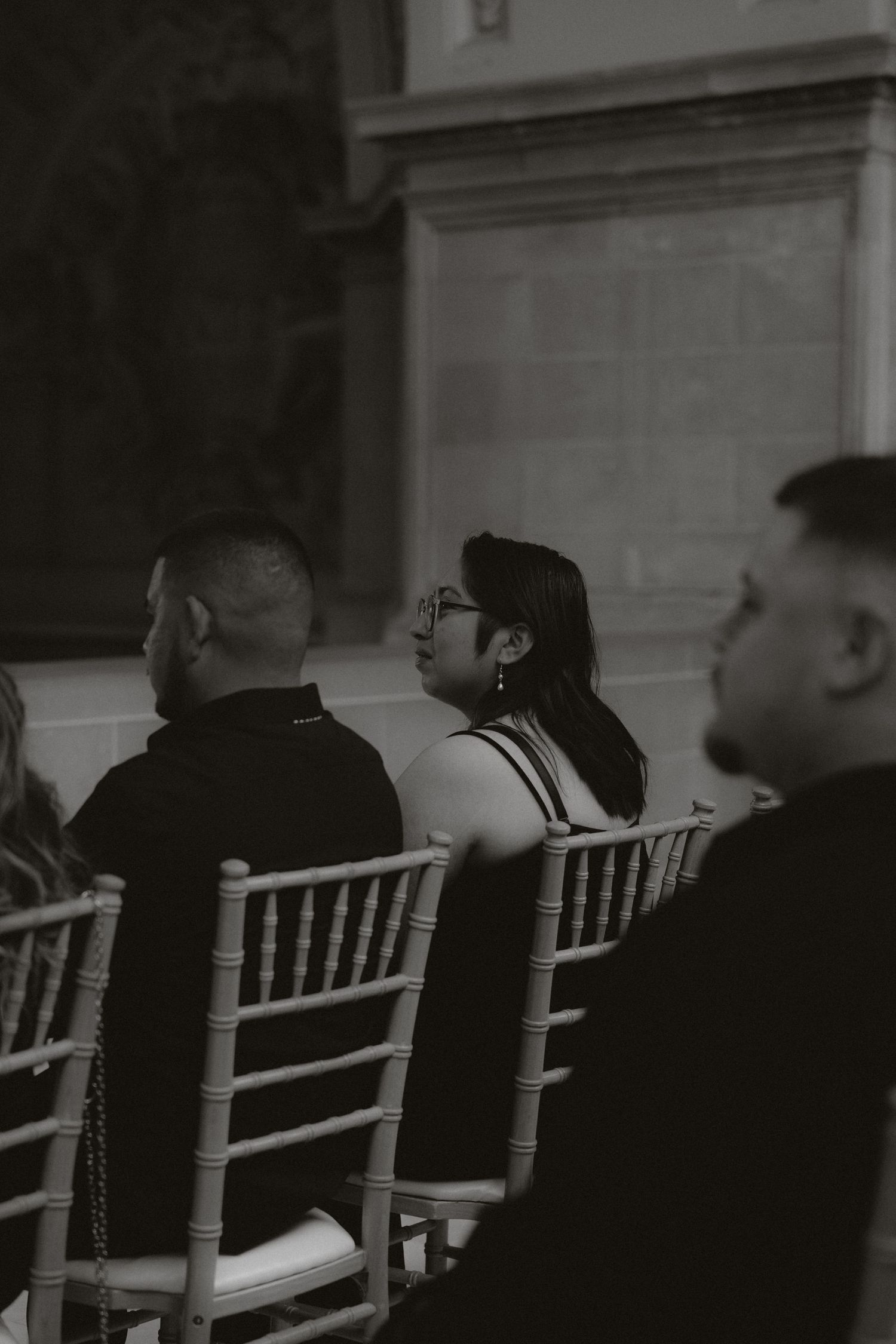 Guests seated in white Chiavari chairs during a formal ceremony.