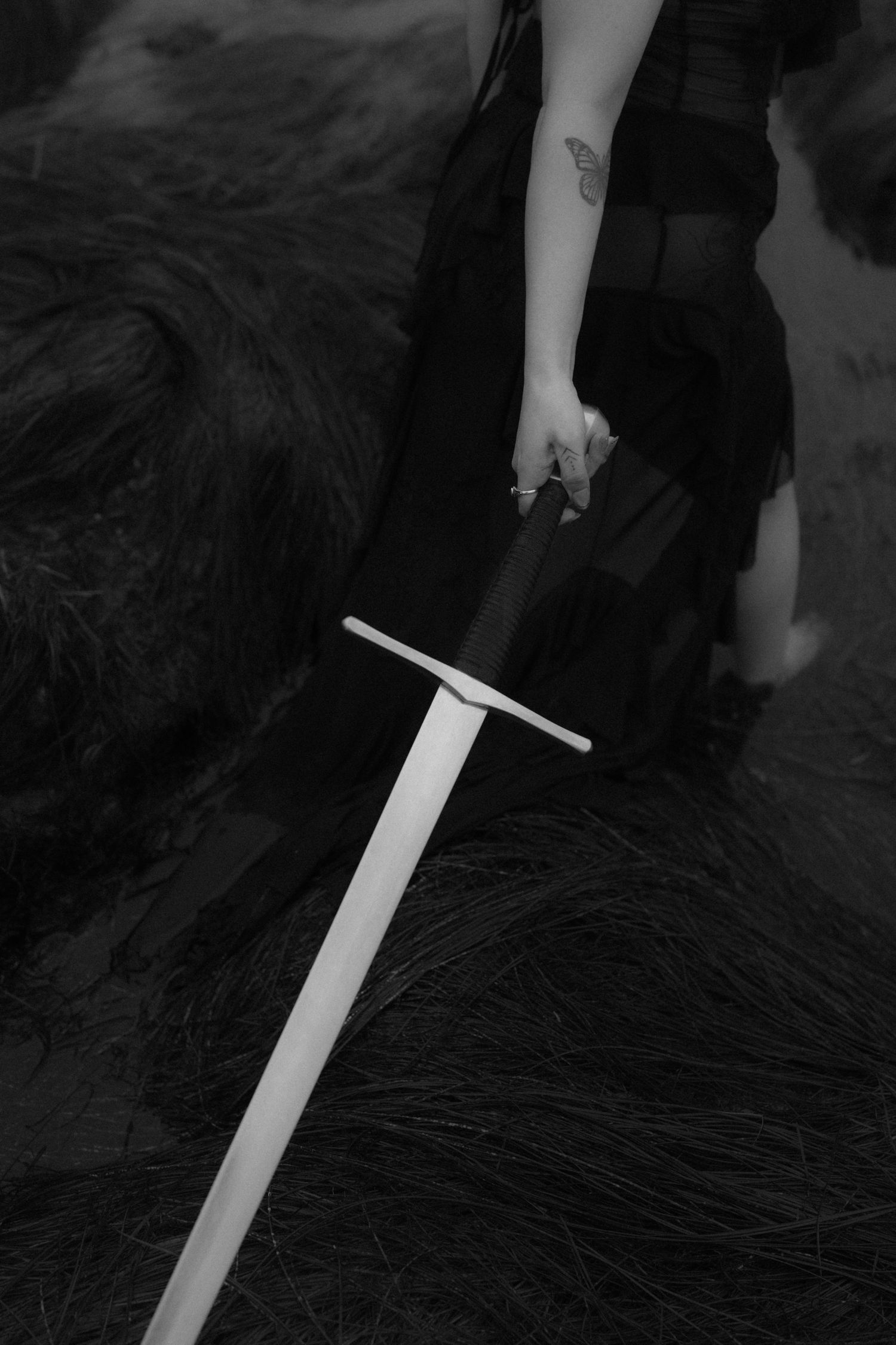 Close-up shot of sword prop against dark textured rocky background.