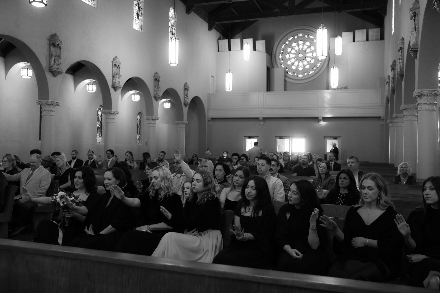 Wide angle view of a church sanctuary filled with wedding guests during a ceremony.