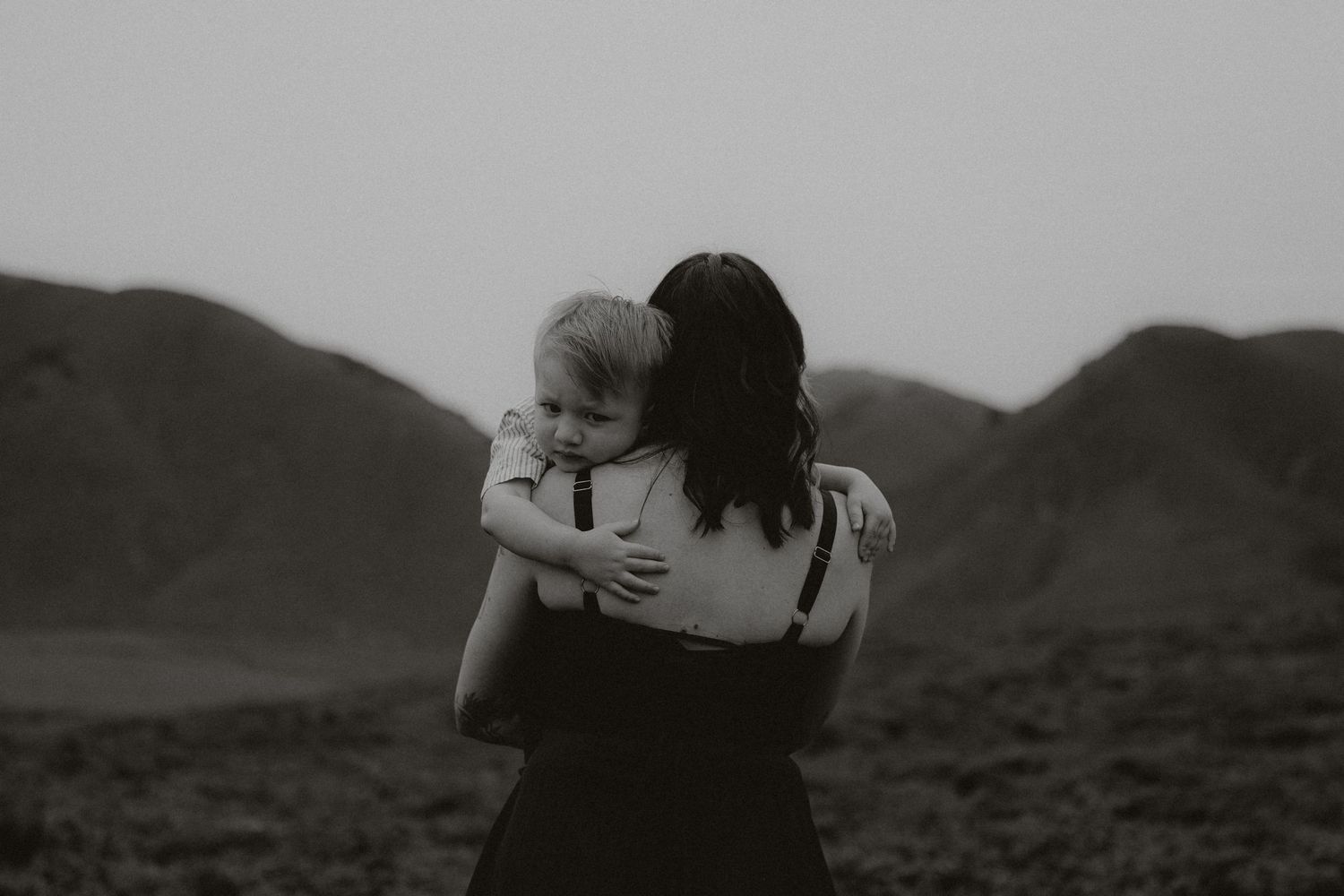 A series of black and white photographs showing couples embracing against a mountainous landscape backdrop.