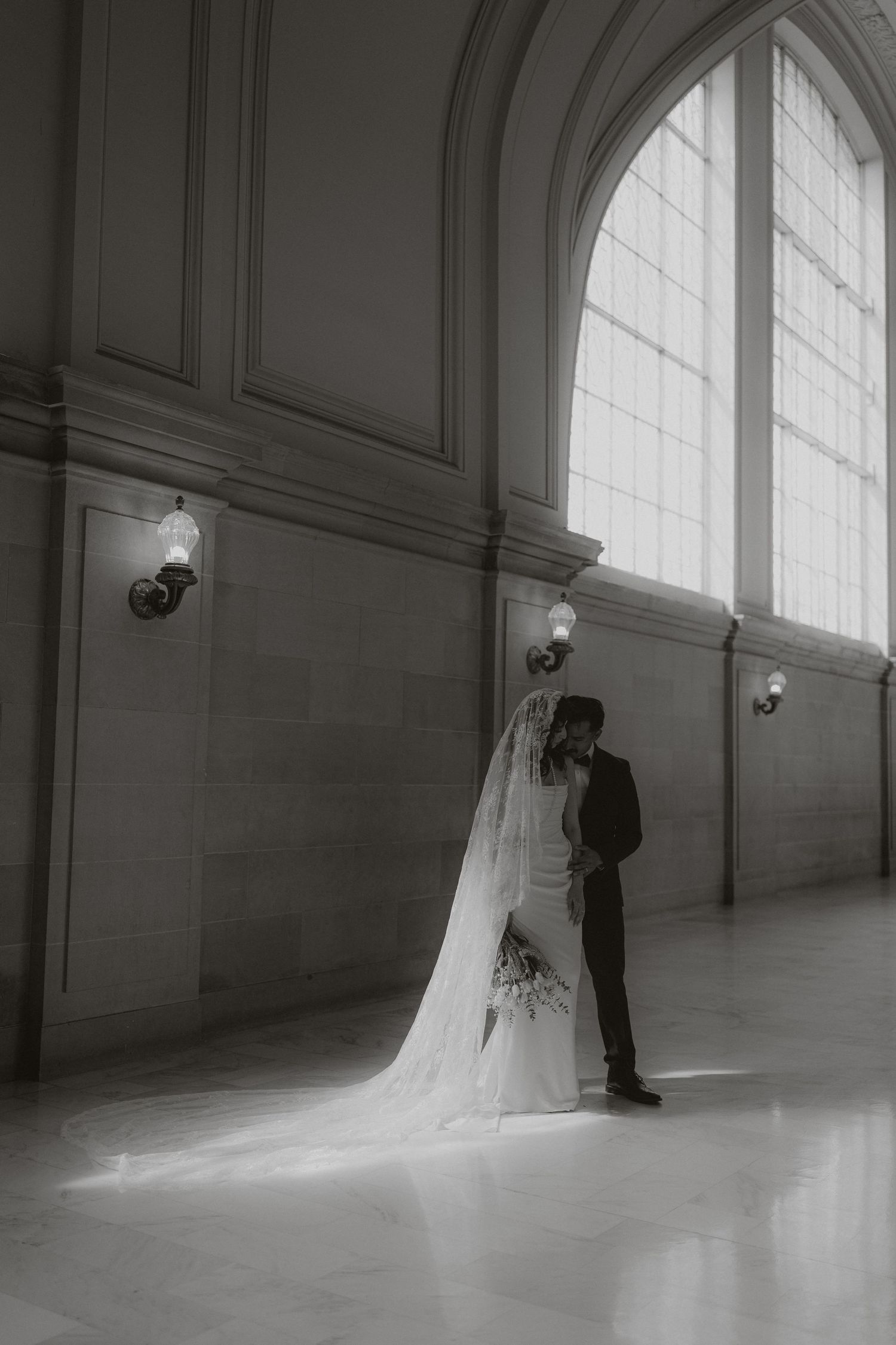 Black and white sequence of a wedding couple in a grand architectural space.