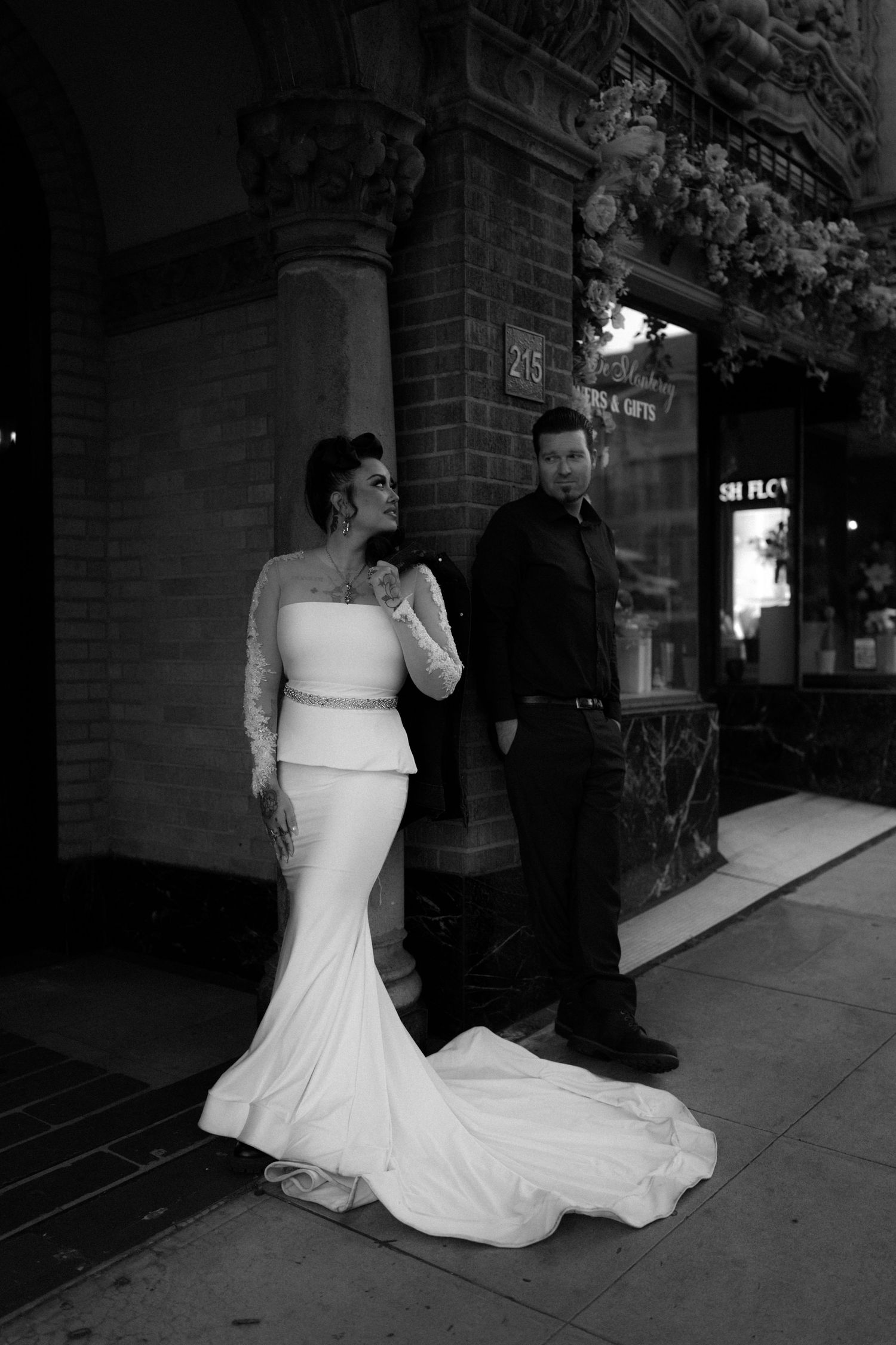 Black and white photo series of a couple against a brick wall with the bride in a white wedding gown.