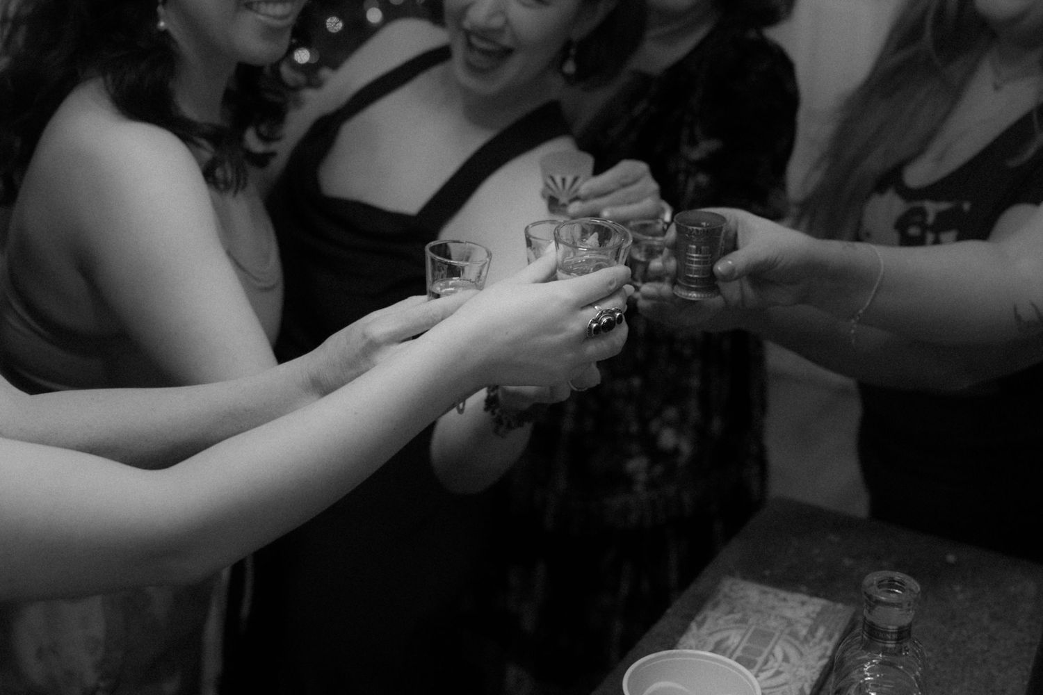 A black and white photograph shows hands exchanging money in a dimly lit setting.