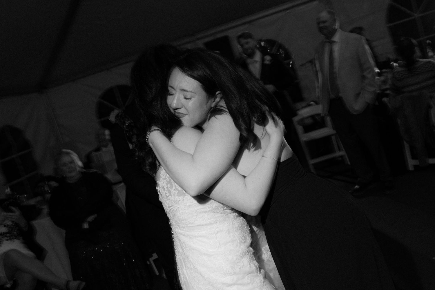 Guests enjoying themselves on a dark dance floor at a wedding celebration.
